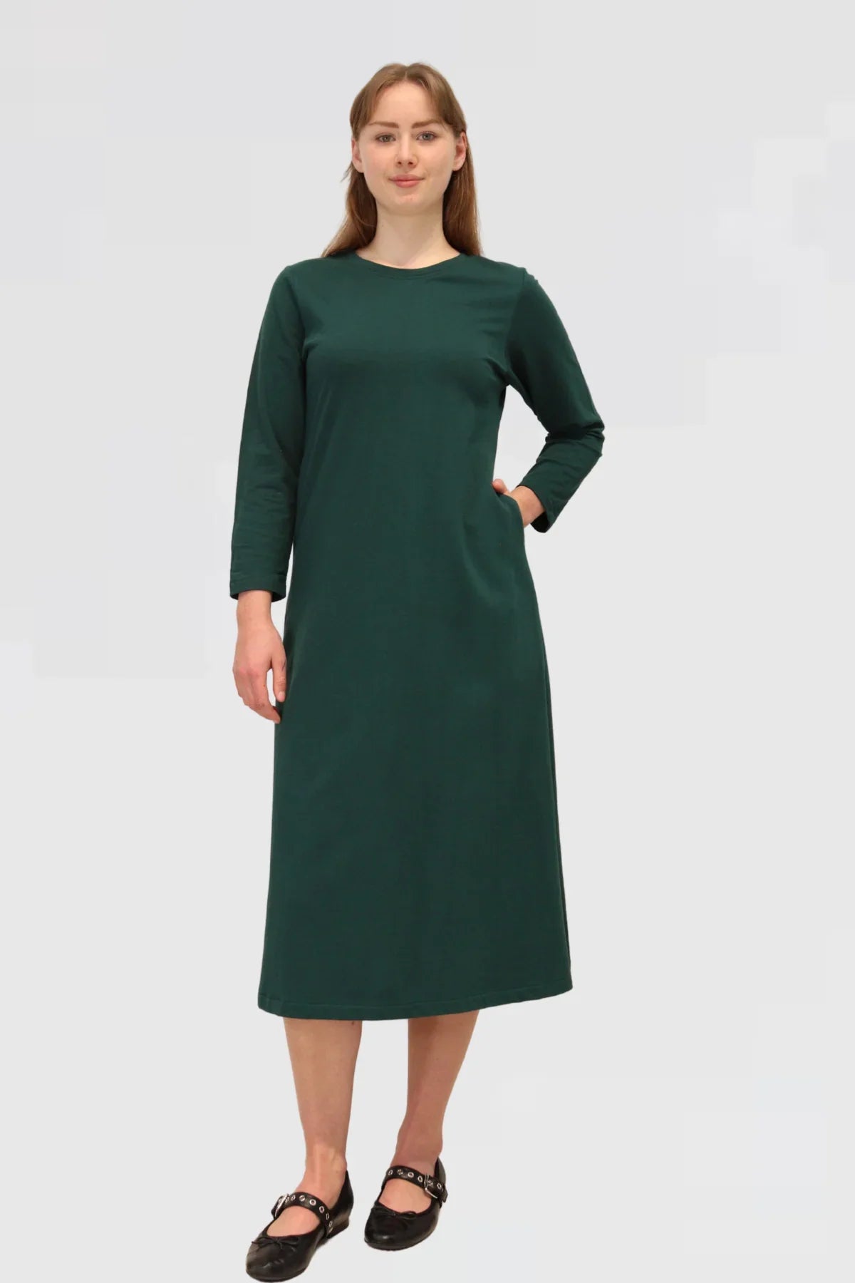 Woman wearing a green dress on a plain background