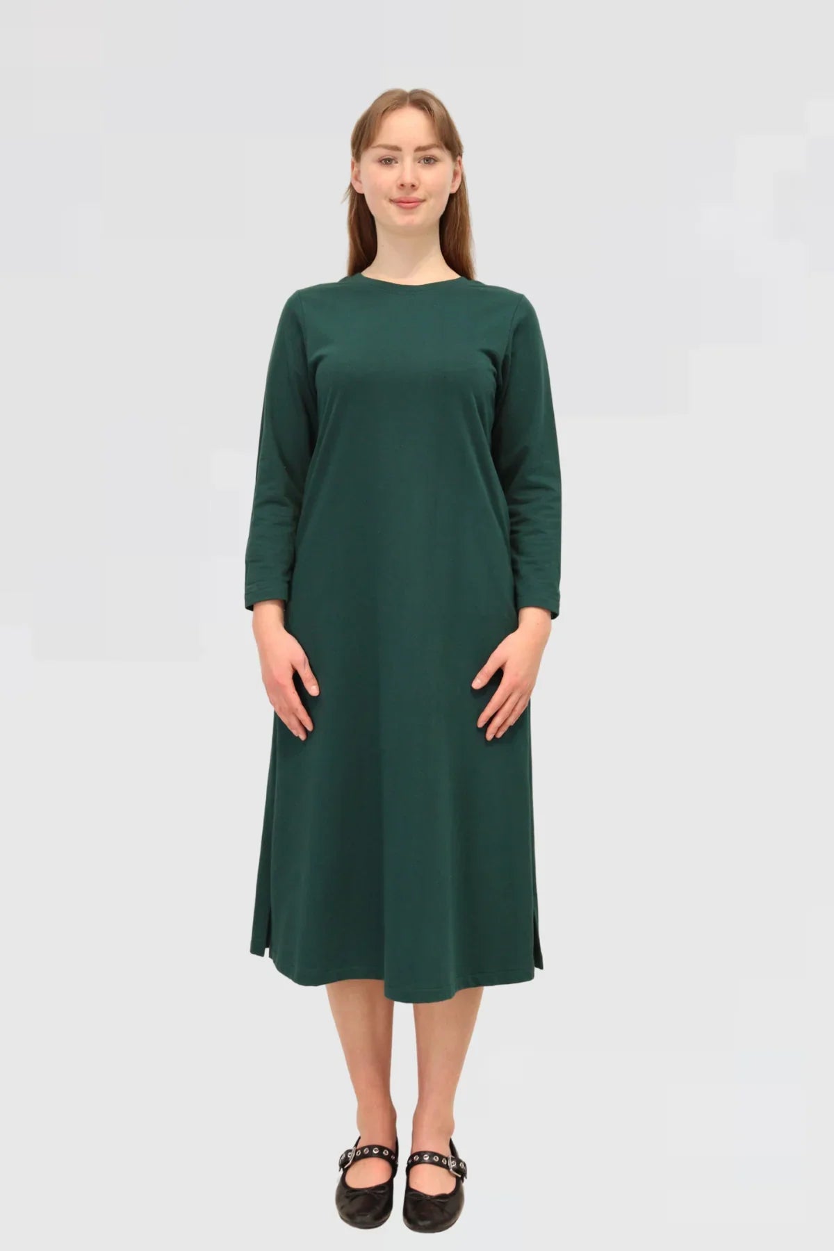 Woman wearing a green dress on a plain background