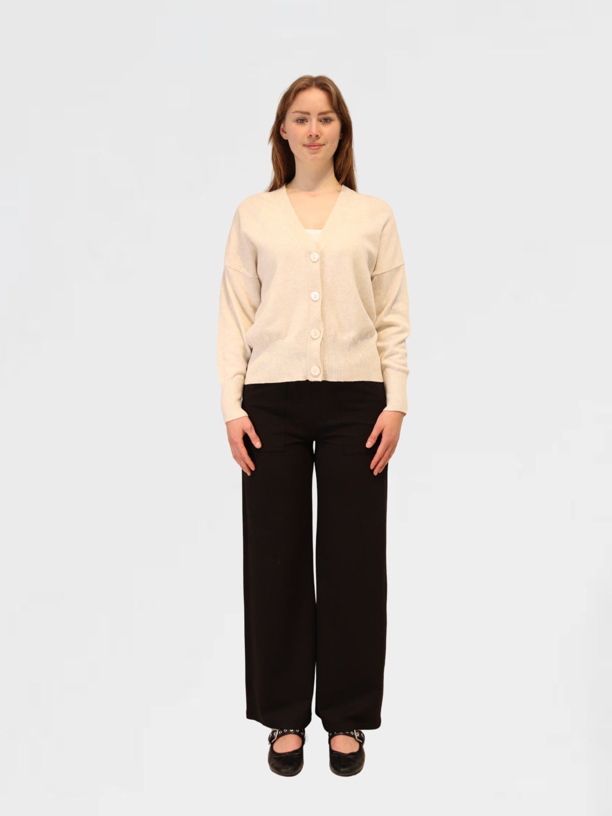 Woman wearing grey marle cashmere and cotton cardigan and black pants on a white background