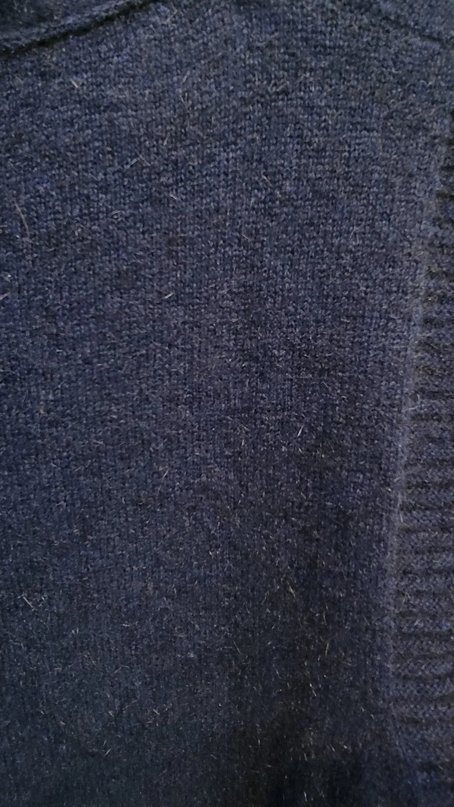 Close-up of dark blue knitted fabric texture with visible weave pattern