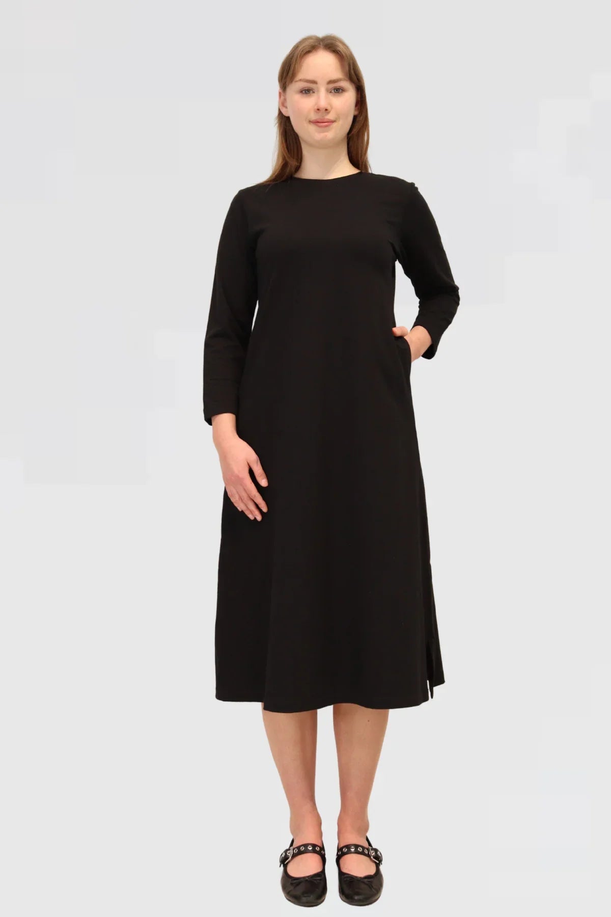 Woman wearing a black dress on a plain background