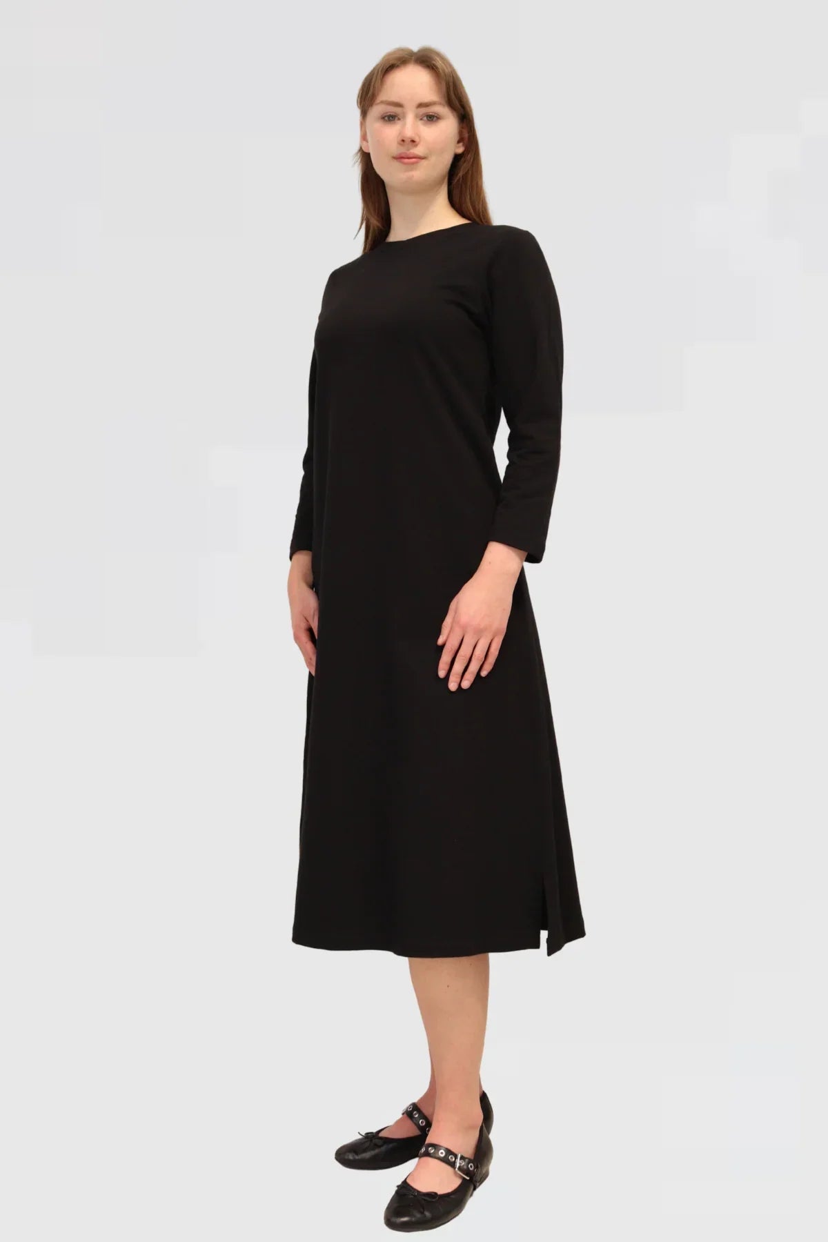 Woman wearing a black dress on a plain background