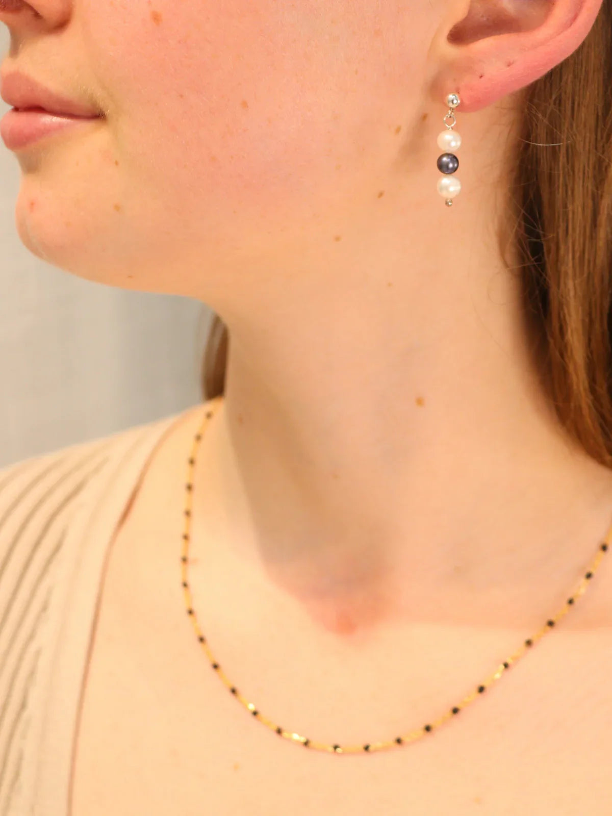 Side profile of woman showcasing silver triple pearl drop earrings, ethically made with lustrous freshwater pearls.