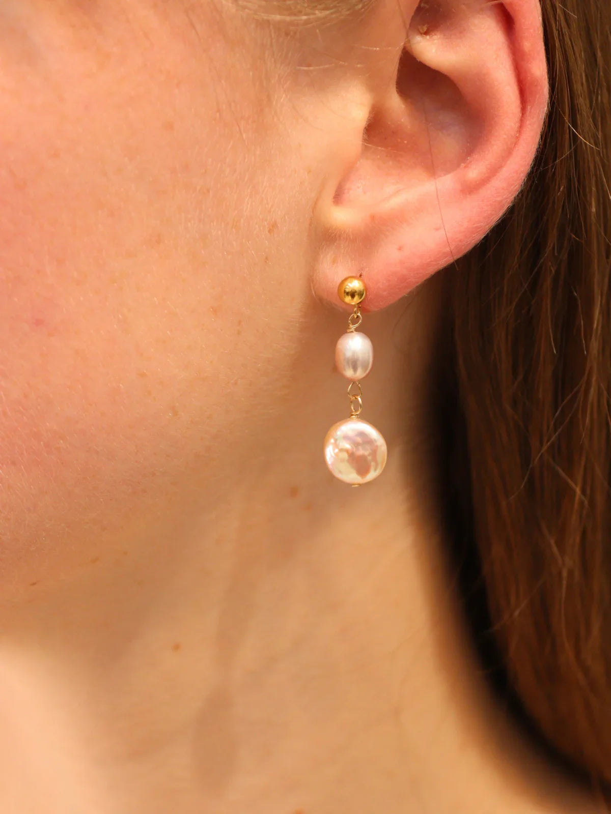 Pearl earring worn by a person with a neutral background
