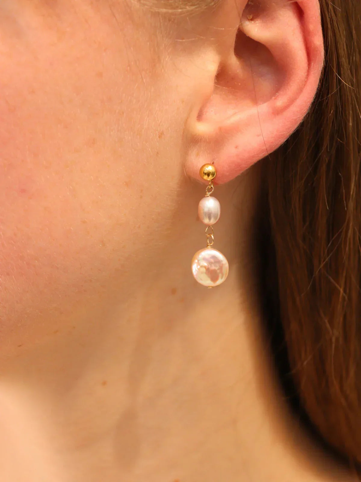 Pearl earring worn by a person with a neutral background