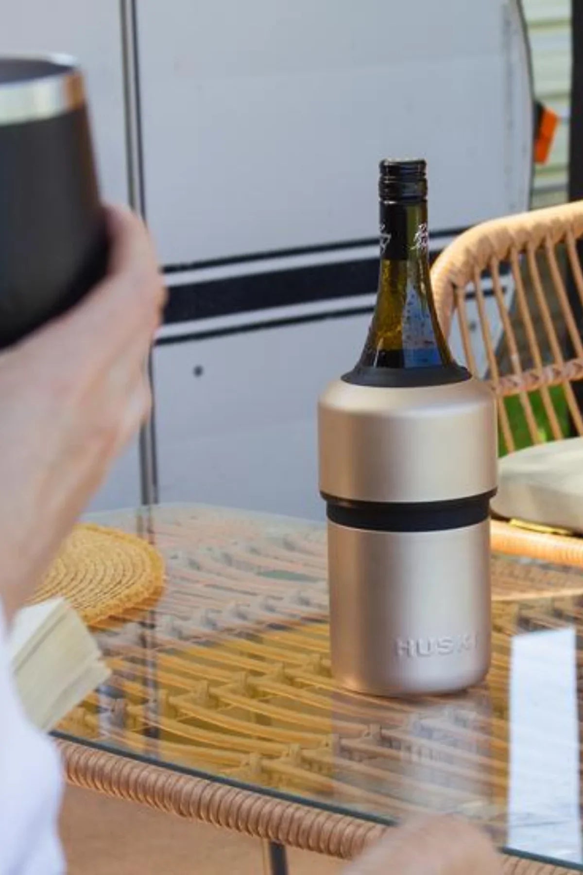 Gold wine bottle cooler on a glass table with a blurred background