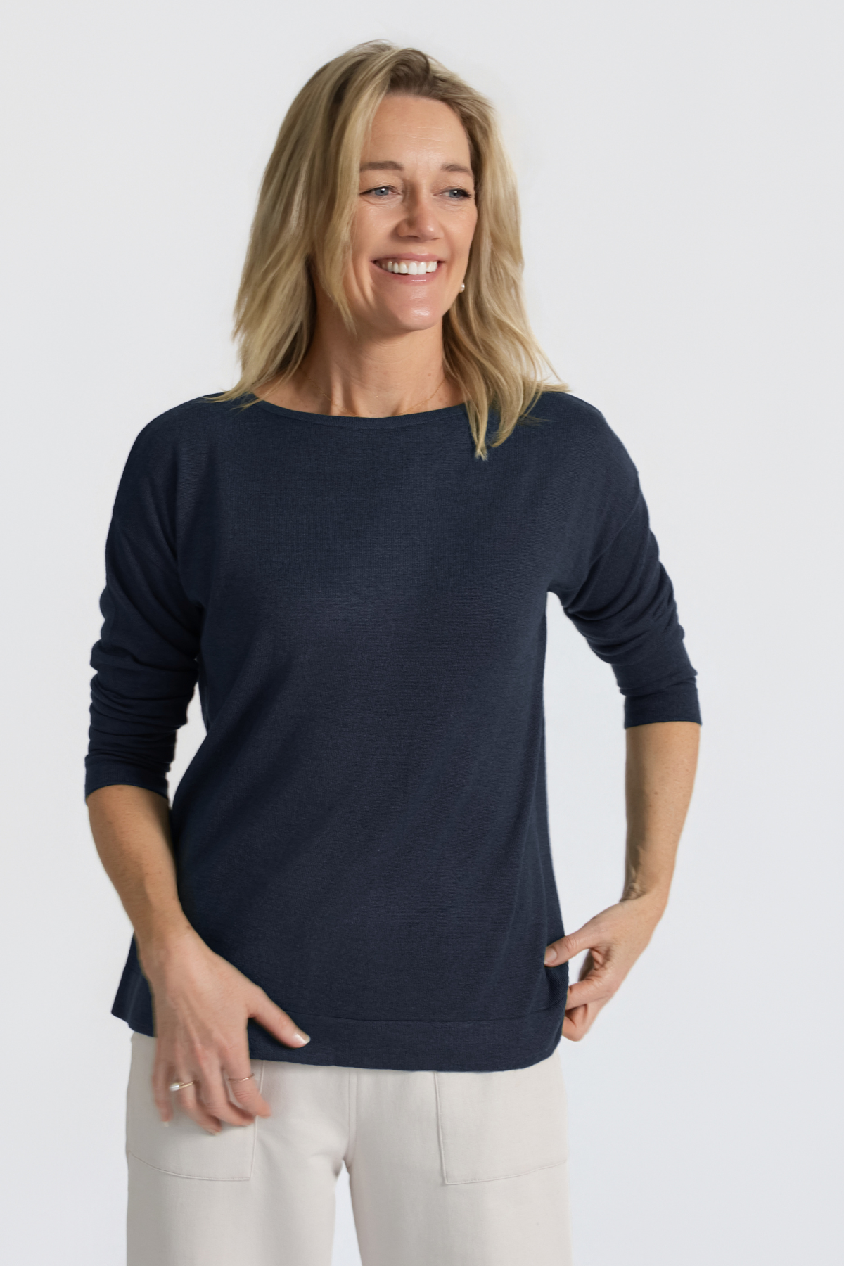 Model wearing the Cosmic Blue Silk Cashmere Knit — three-quarter front view with hands resting at hips