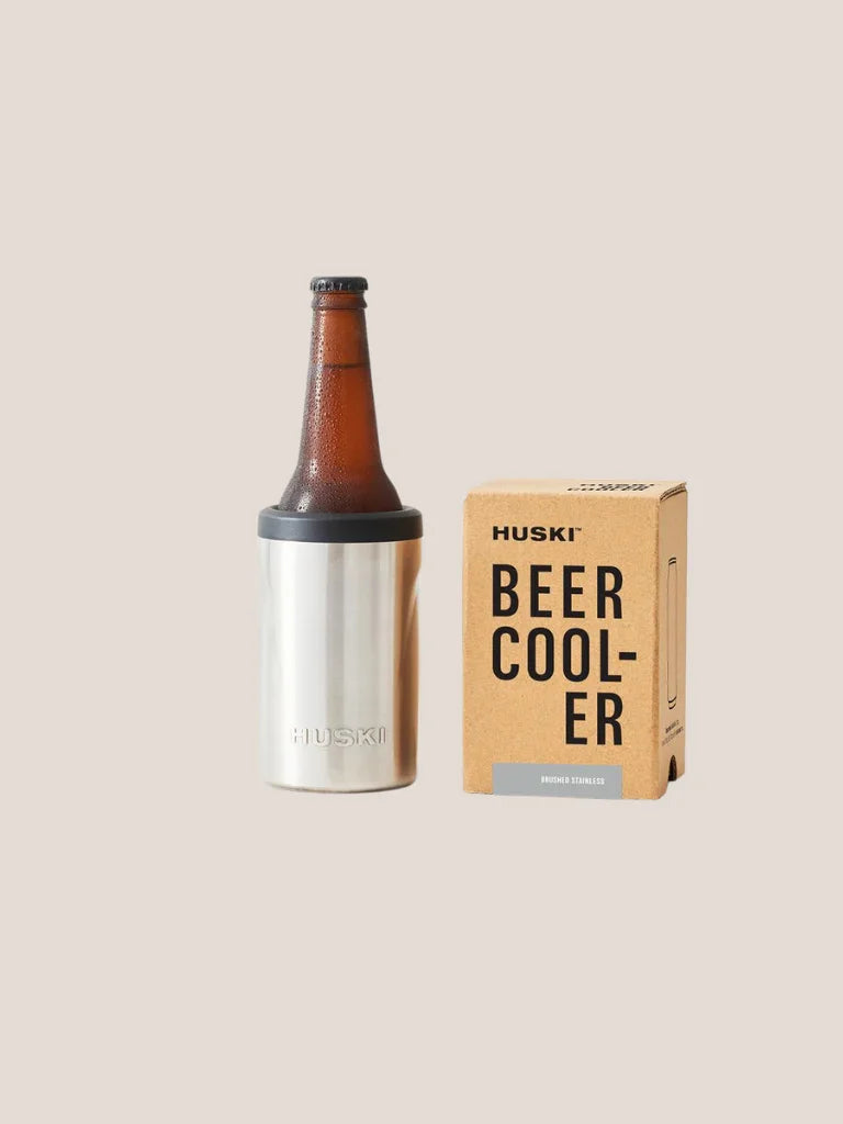 Huski beer cooler with a bottle and packaging on a beige background