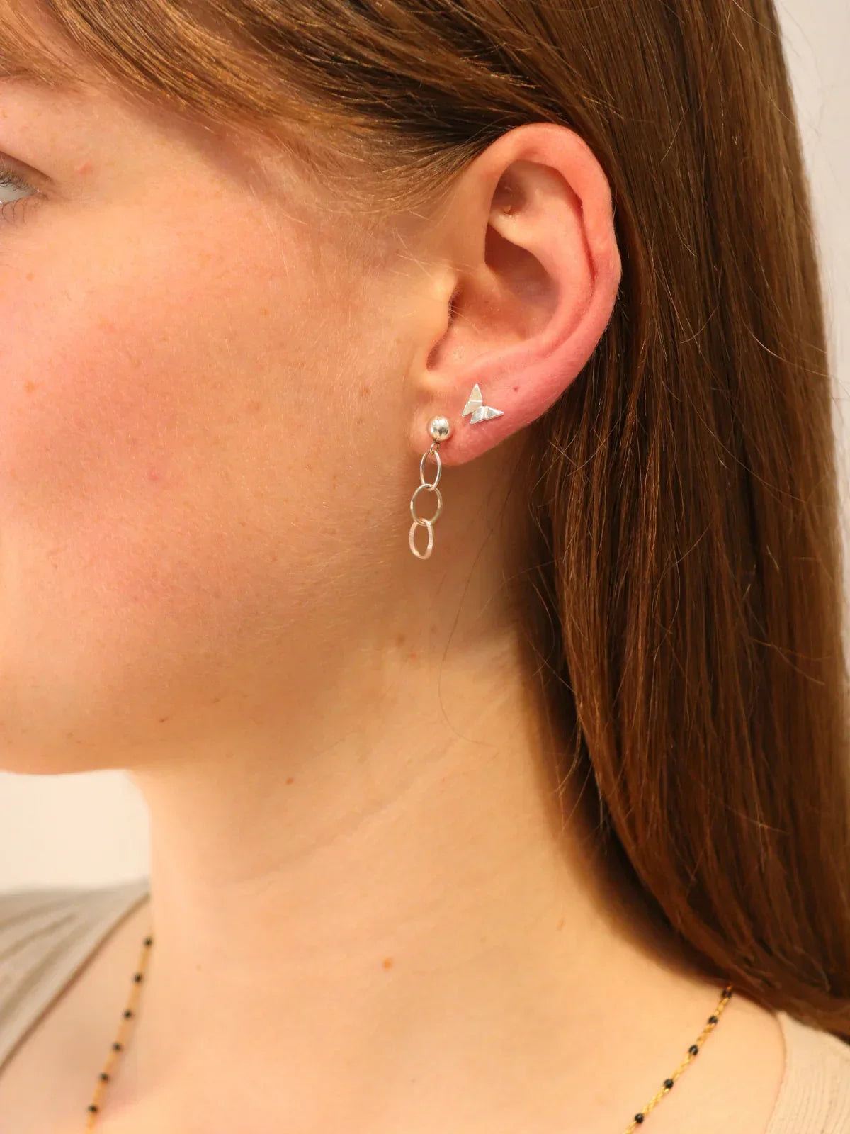 Side view of sterling silver double hoop drop earrings with butterfly stud, elegant lightweight design.