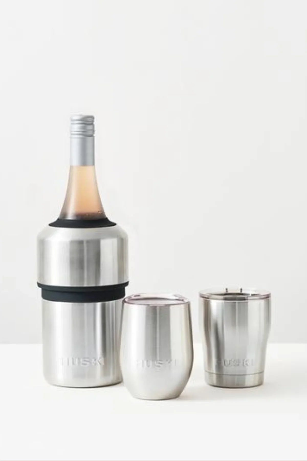 Silver wine bottle cooler with two matching tumblers on a white background