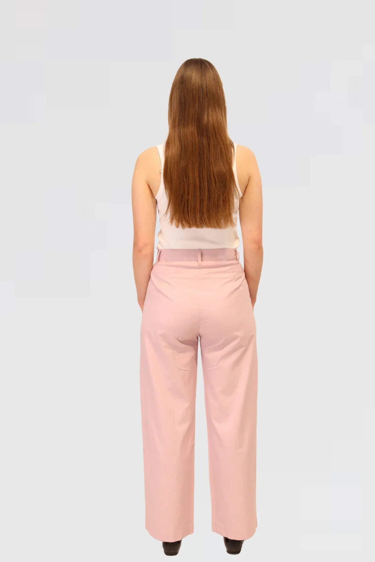 Woman wearing a white top and pink pants 48% cotton, 29% TENCEL™, and 23% linen