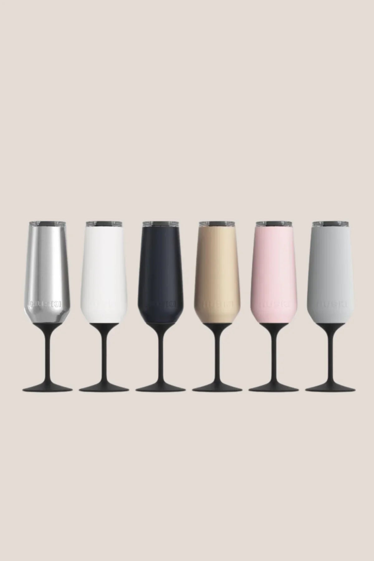 Set of six champagne flutes in different colors on a beige background