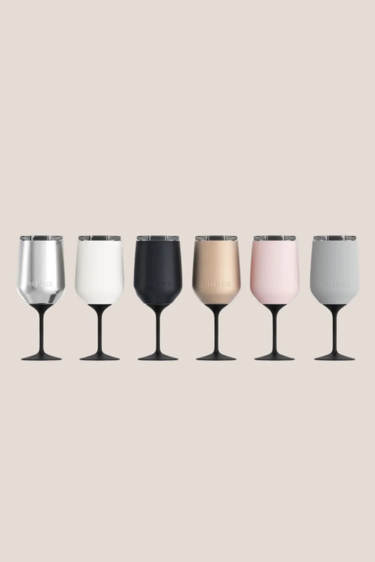 Set of six wine glasses in various colors on a beige background