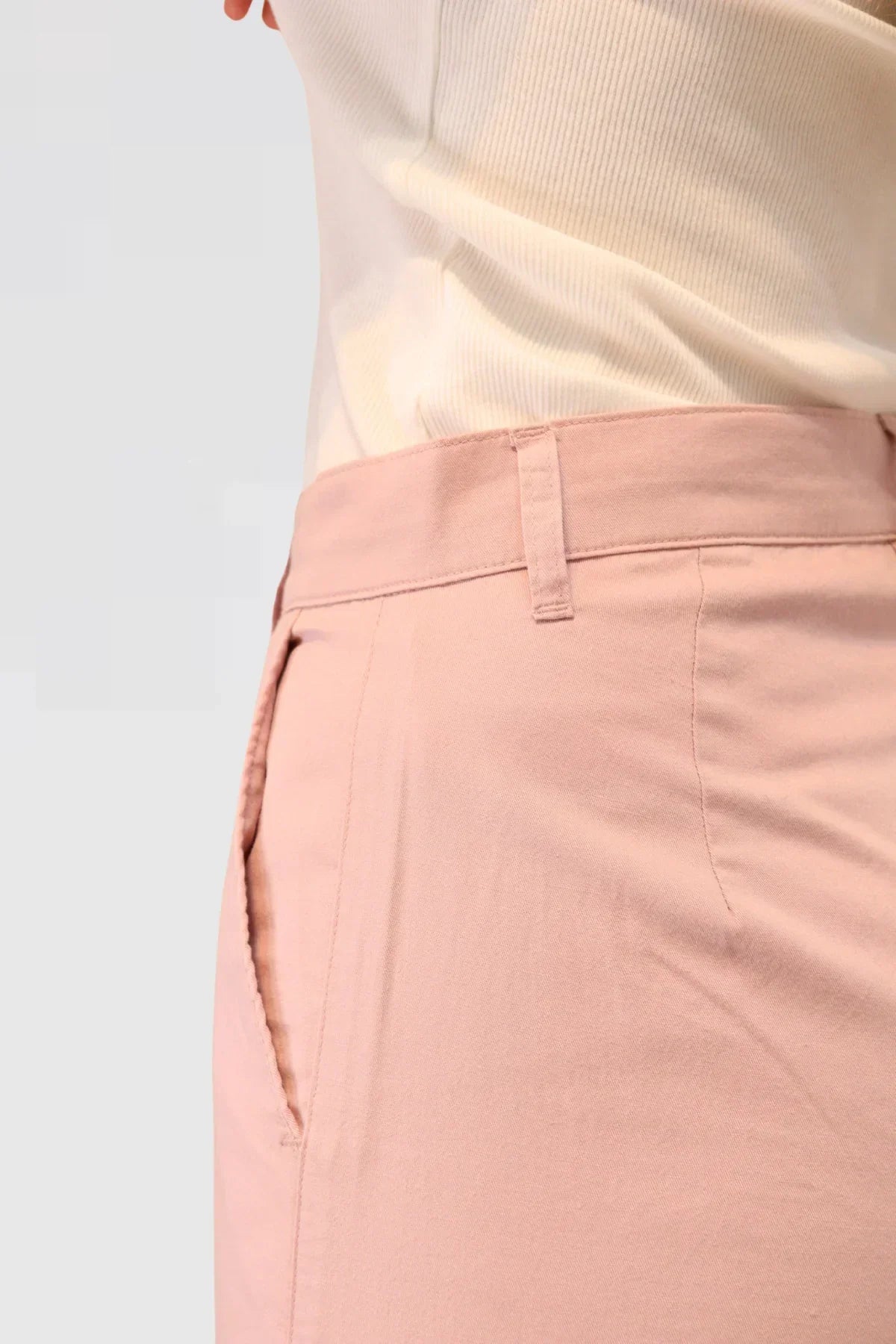 Close-up of pink pants 48% cotton, 29% TENCEL™, and 23% linen and a white top on a light grey background