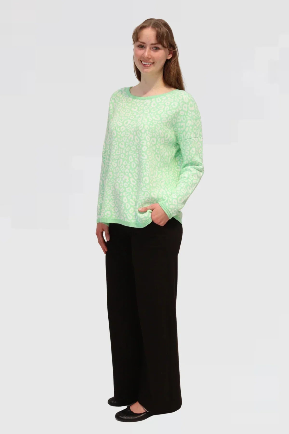 Woman wearing Cotton Jacquard Sweater - Apple green and black pants on a white background