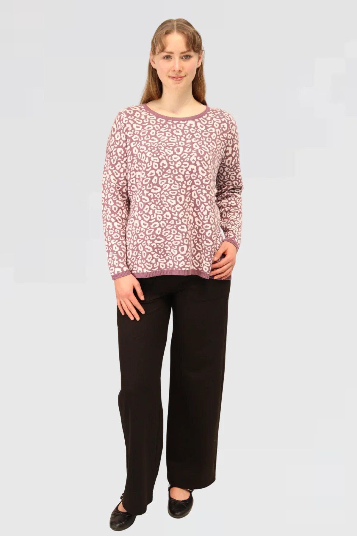 Woman wearing a Cotton Jacquard Sweater - Mauver and black pants on a light gray background