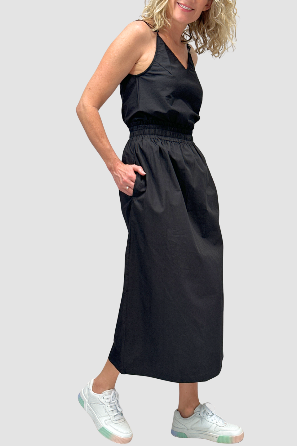 Woman wearing a black sleeveless top with Cotton Maxi Skirt - with white sneakers on a light gray background
