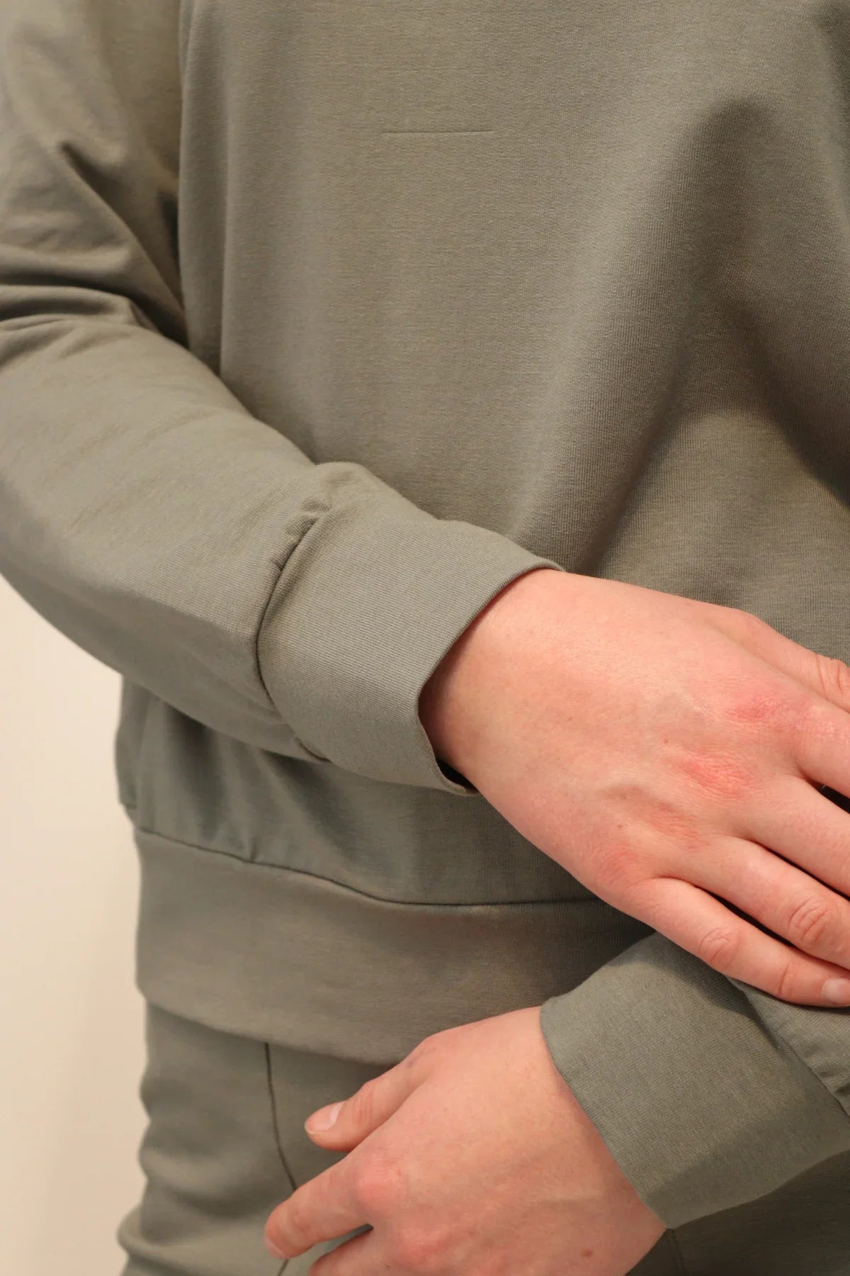 Detail shot of Agave Organic Cotton Sweater cuff and fabric texture, paired with Reca Agave Drape Trousers.