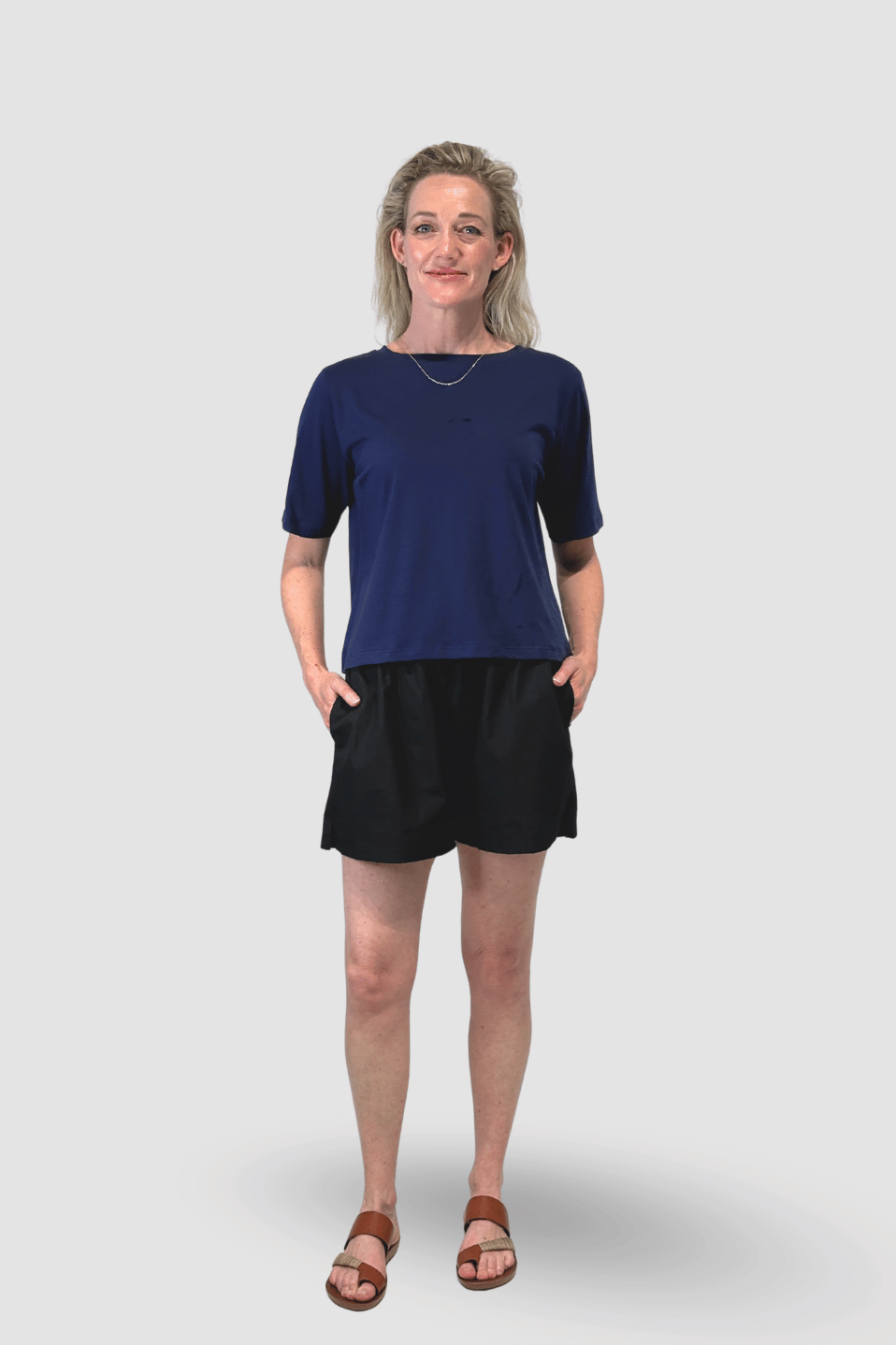 Woman wearing a navy organic cotton top and black cotton shorts