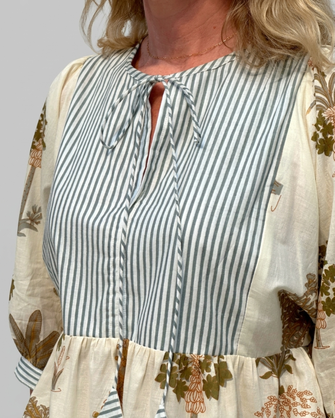 Close-up of the Botanica Luxe Cotton Blouse showing the sage and white striped bodice panel and delicate self-tie split neckline
