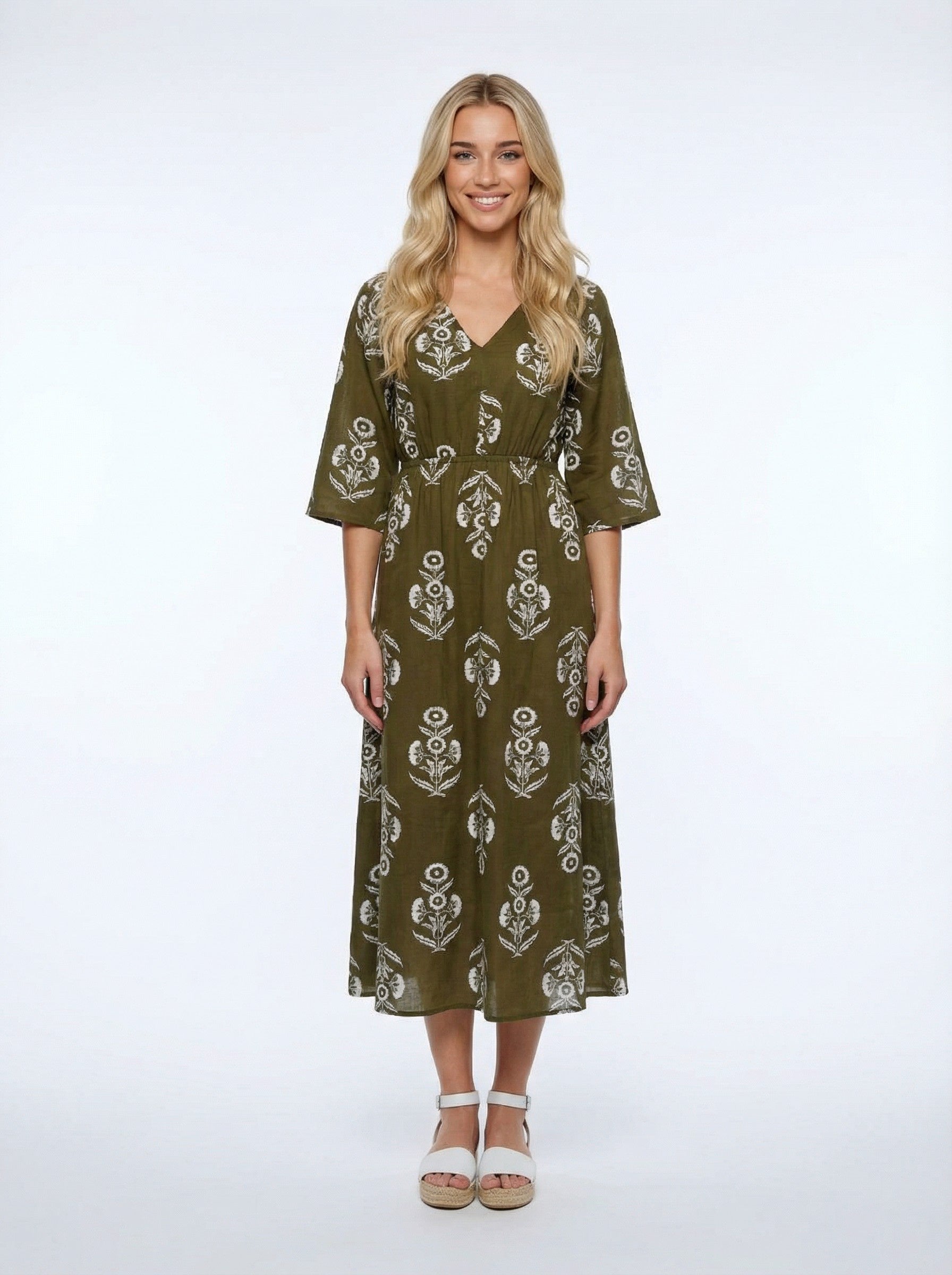 Woman wearing a green patterned dress on a white background