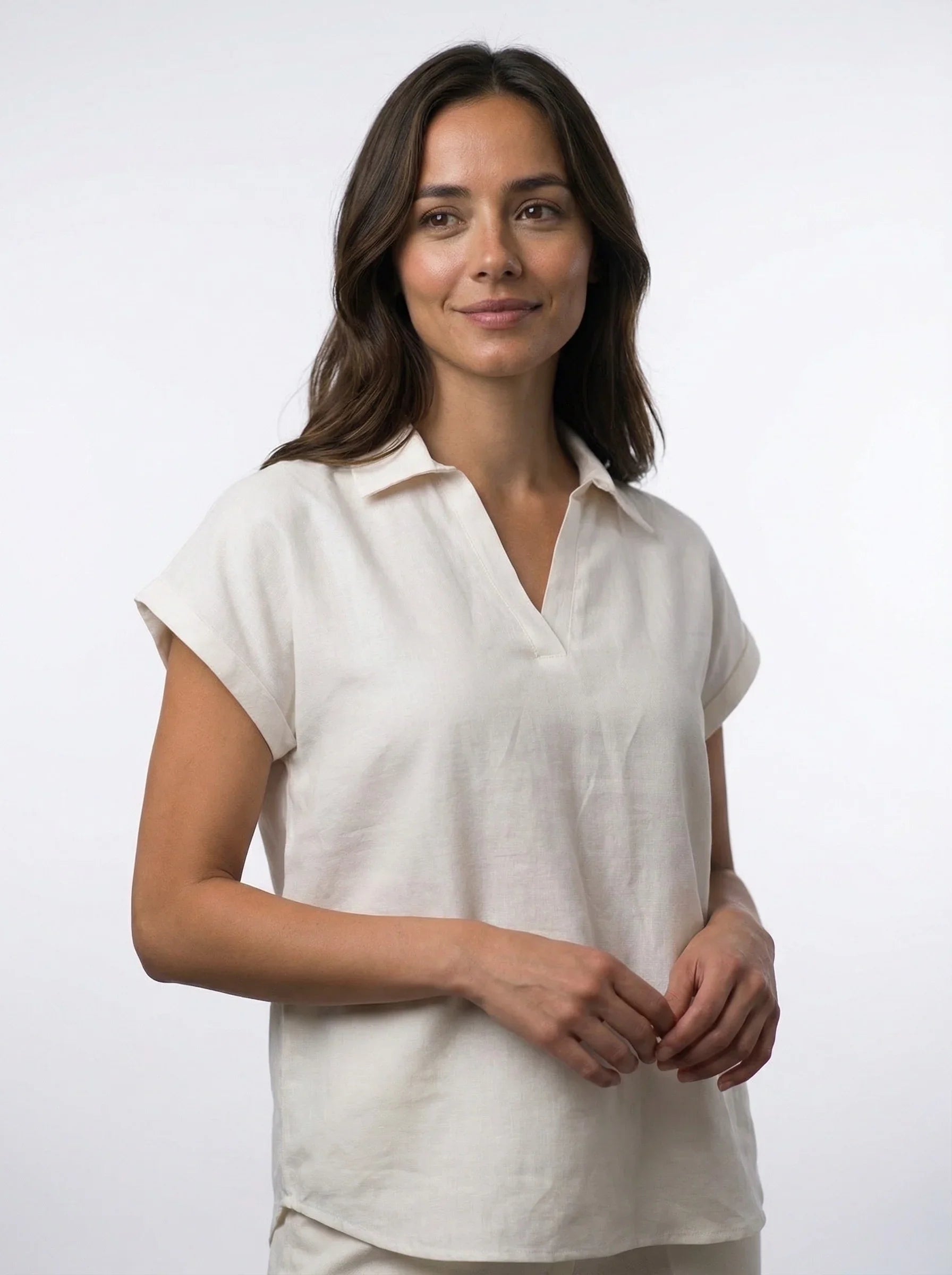 Woman wearing ethical Reca cream short-sleeve linen blouse on white background