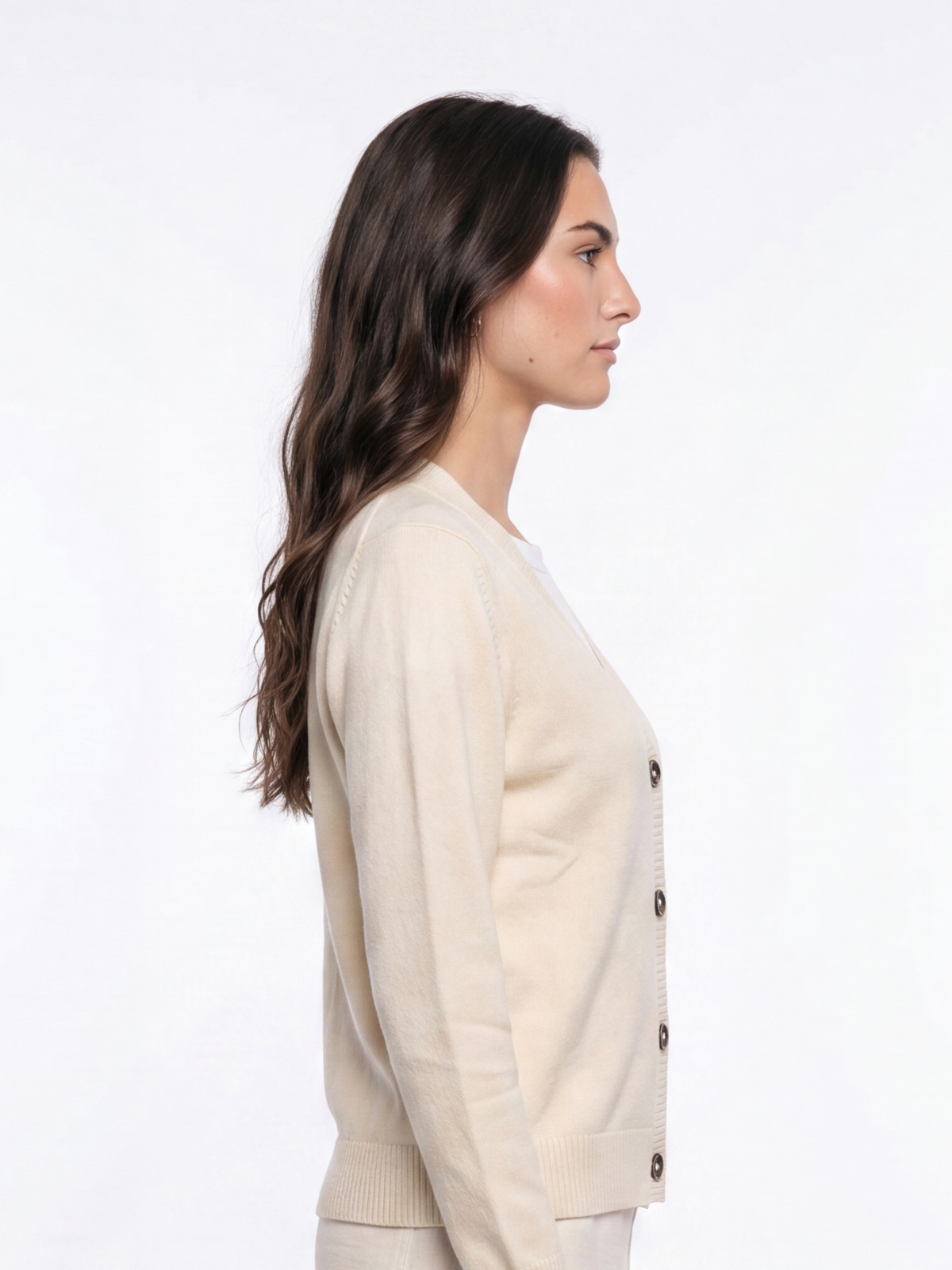 Side profile of woman wearing a natural cream Cashmere-Merino Cardigan with matching trousers
