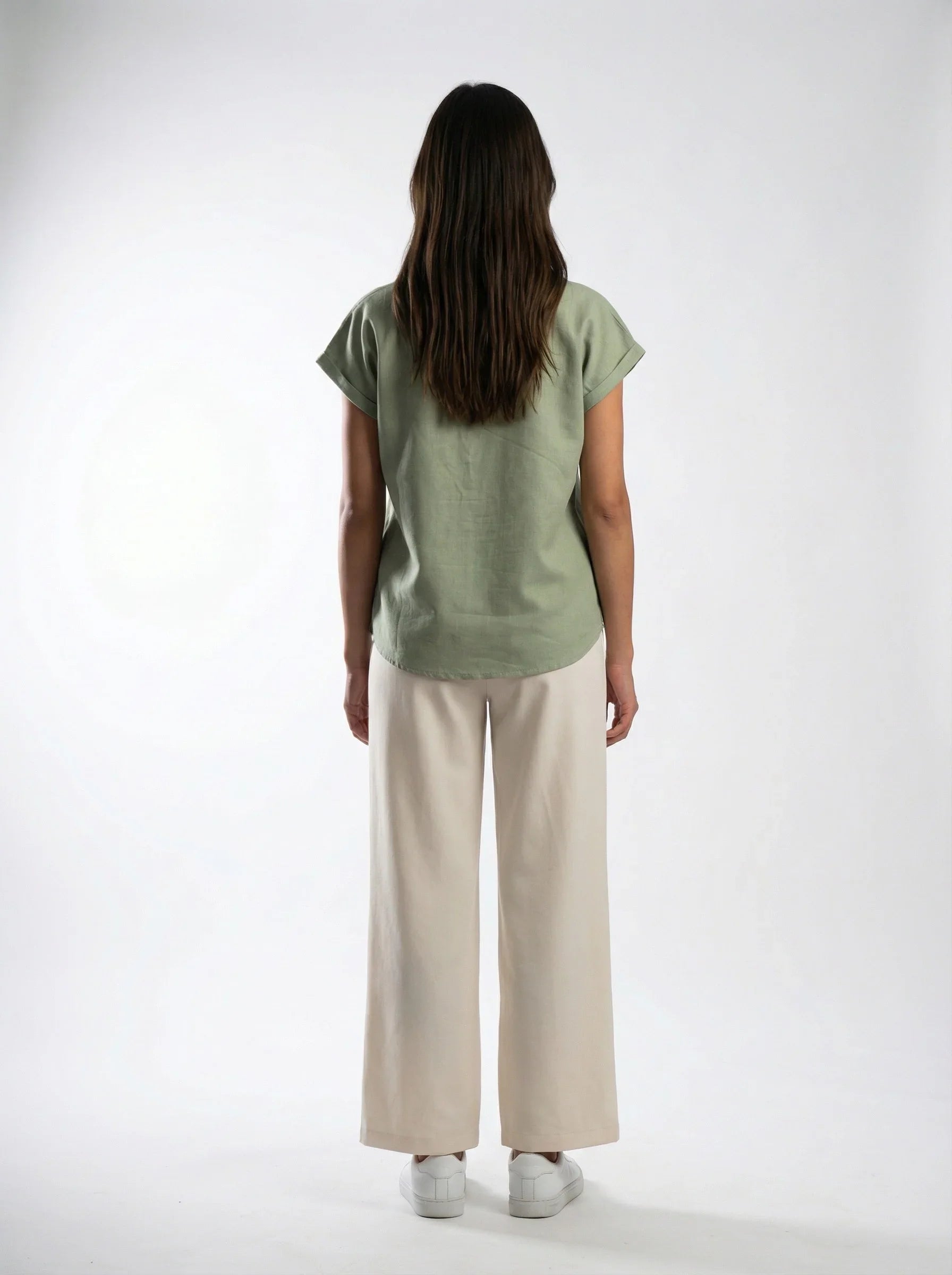 Woman wearing ethical green top and cream wide-leg pants, Reca clothing fashion