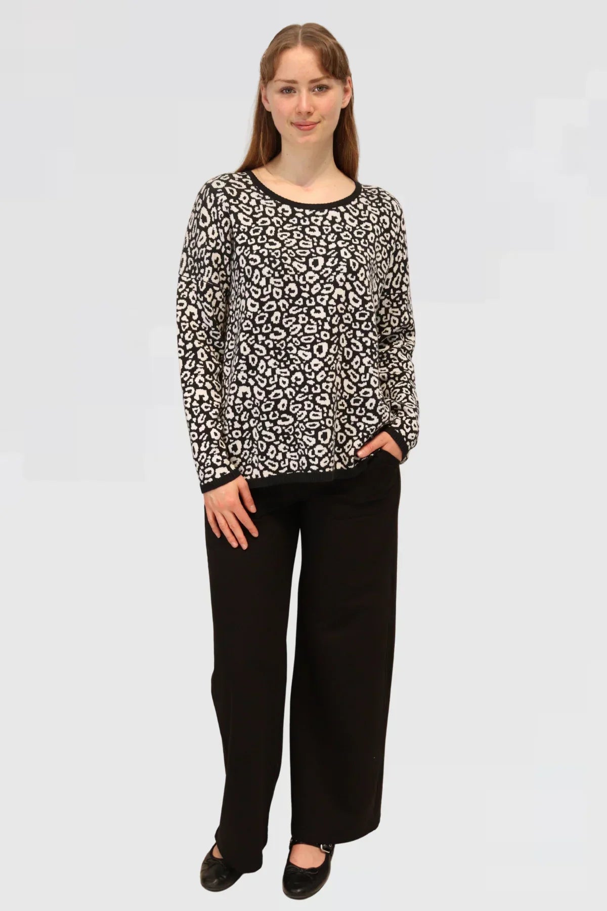 Woman wearing a Cotton Jacquard Sweater - Apple green with black pants on a light gray background