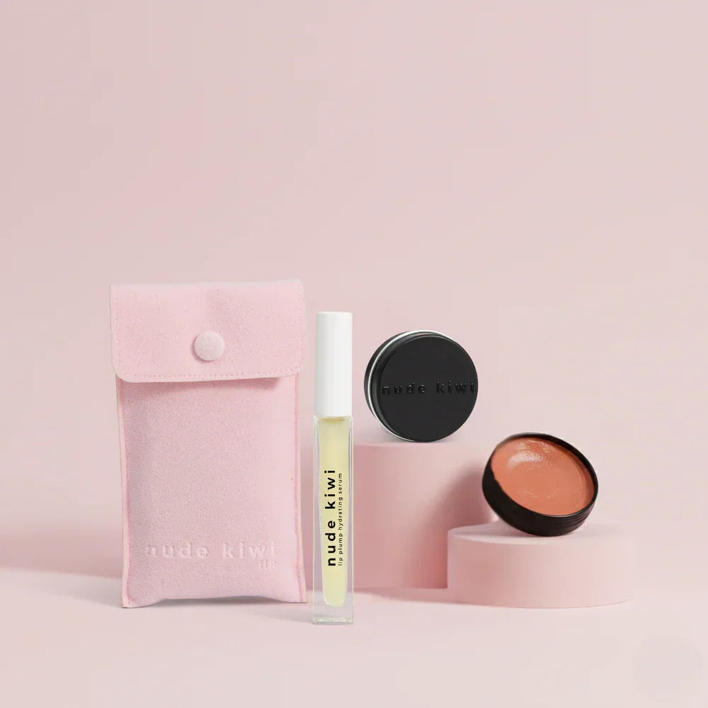 Makeup products including a pink pouch, lip balm, and compact on a light pink background with 'nude kiwi' branding.