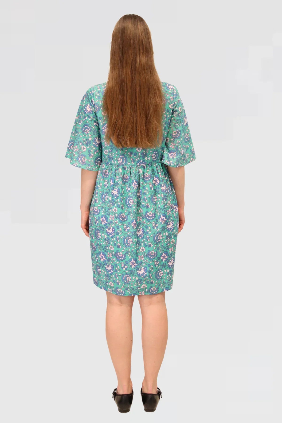 Back view of Petal Tapestry Tiered Dress, displaying floral cotton fabric, tiered design, and loose-fit sleeves.