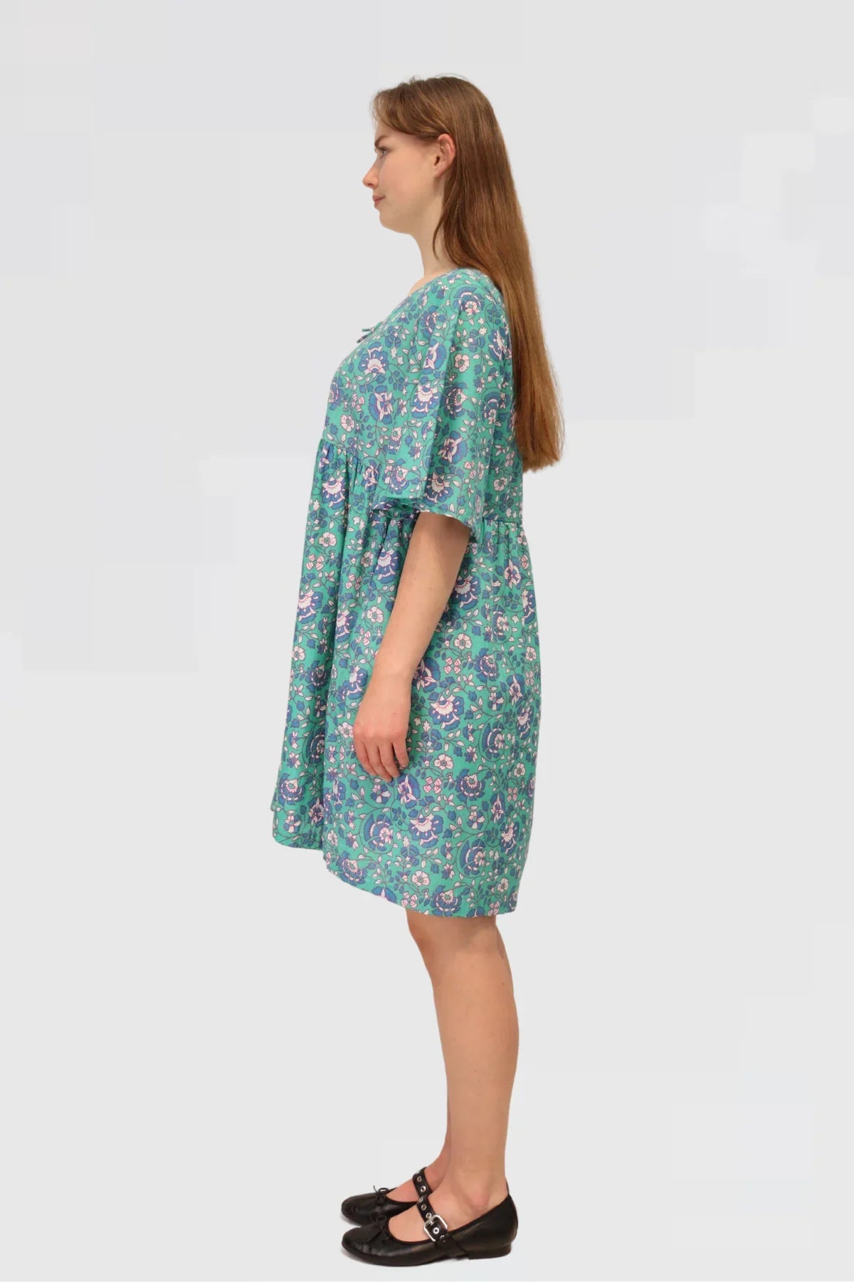 Back view of Petal Tapestry Tiered Dress, displaying floral cotton fabric, tiered design, and loose-fit sleeves.