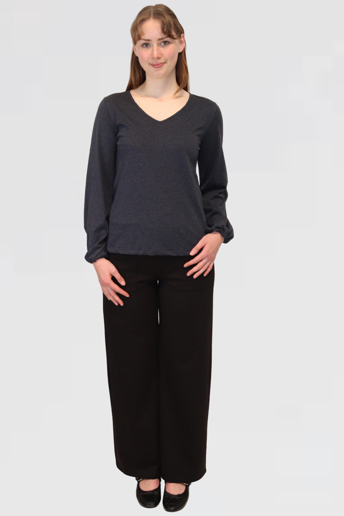 Front view of Reca Bishop Blouse in Ink, featuring V-neckline and bishop sleeves with gathered cuffs, paired with black trousers.