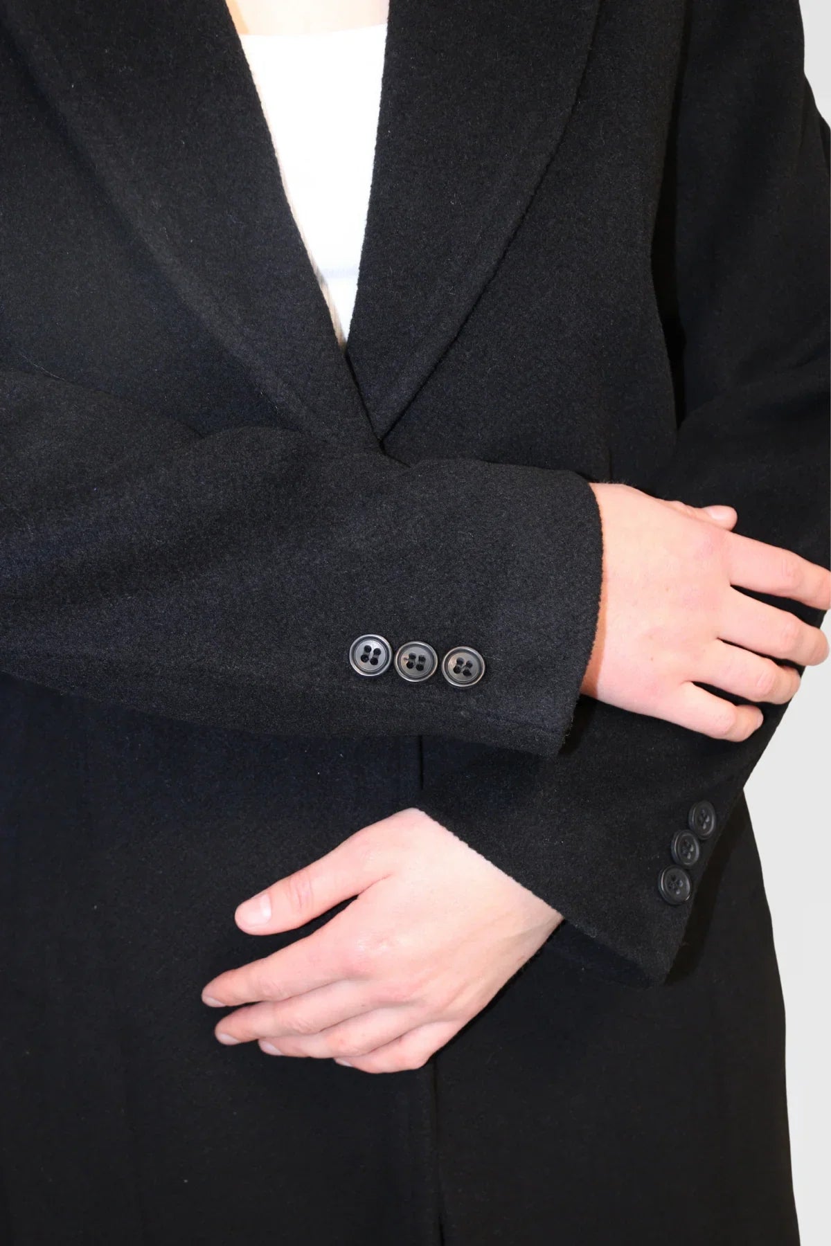 Detail shot of Single-Button Wool Coat in Black, showing sleeve with button detail and wool-blend texture.