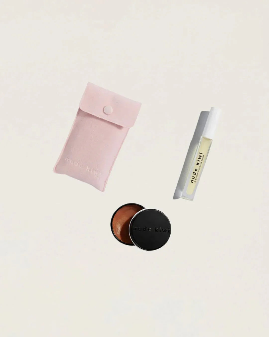 Nude Kiwi Lip Kit flatlay with pink pouch, lip plumping serum, and moisture lock lip balm on a beige background