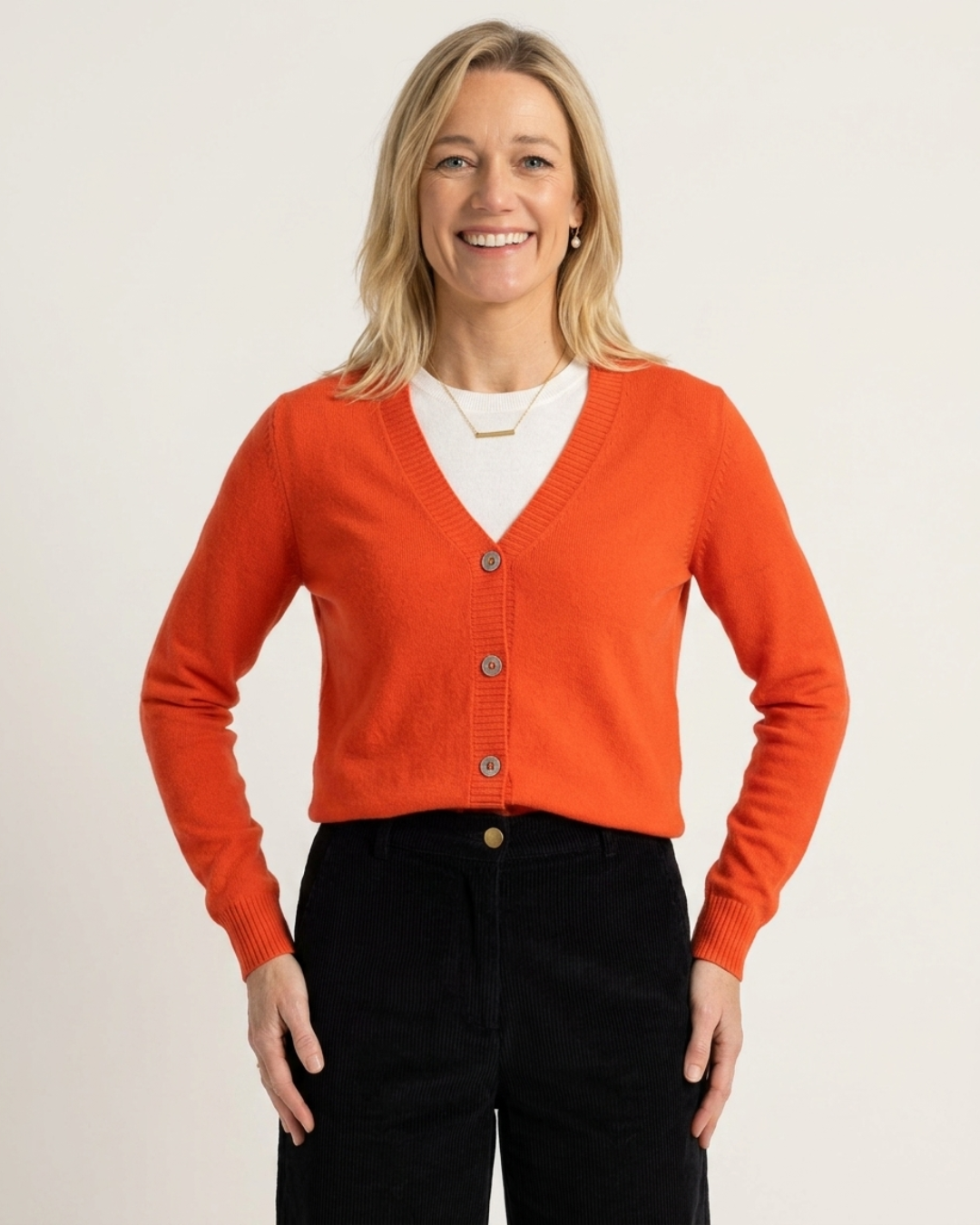 Reca knitwear — a woman wearing the Cashmere-Merino Cardigan in Scarlet, ethically made cashmere and merino