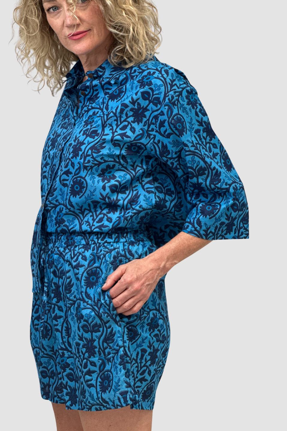 Woman wearing a blue floral dress against a white background