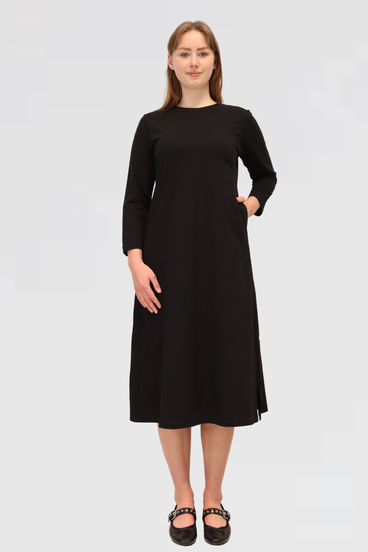 Woman wearing a black dress on a plain background