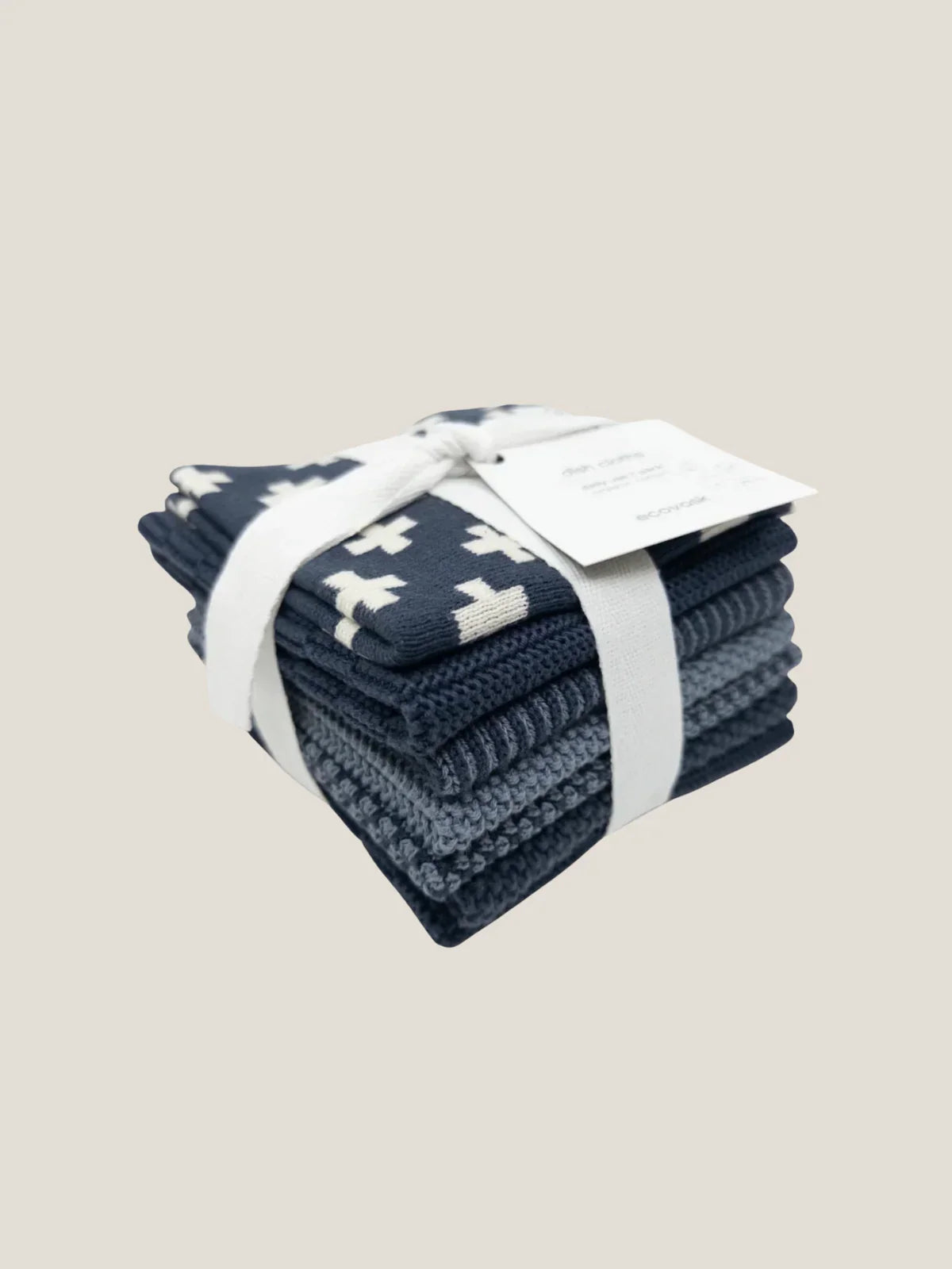 Stack of blue cotton dishcloth with white patterns on a beige background
