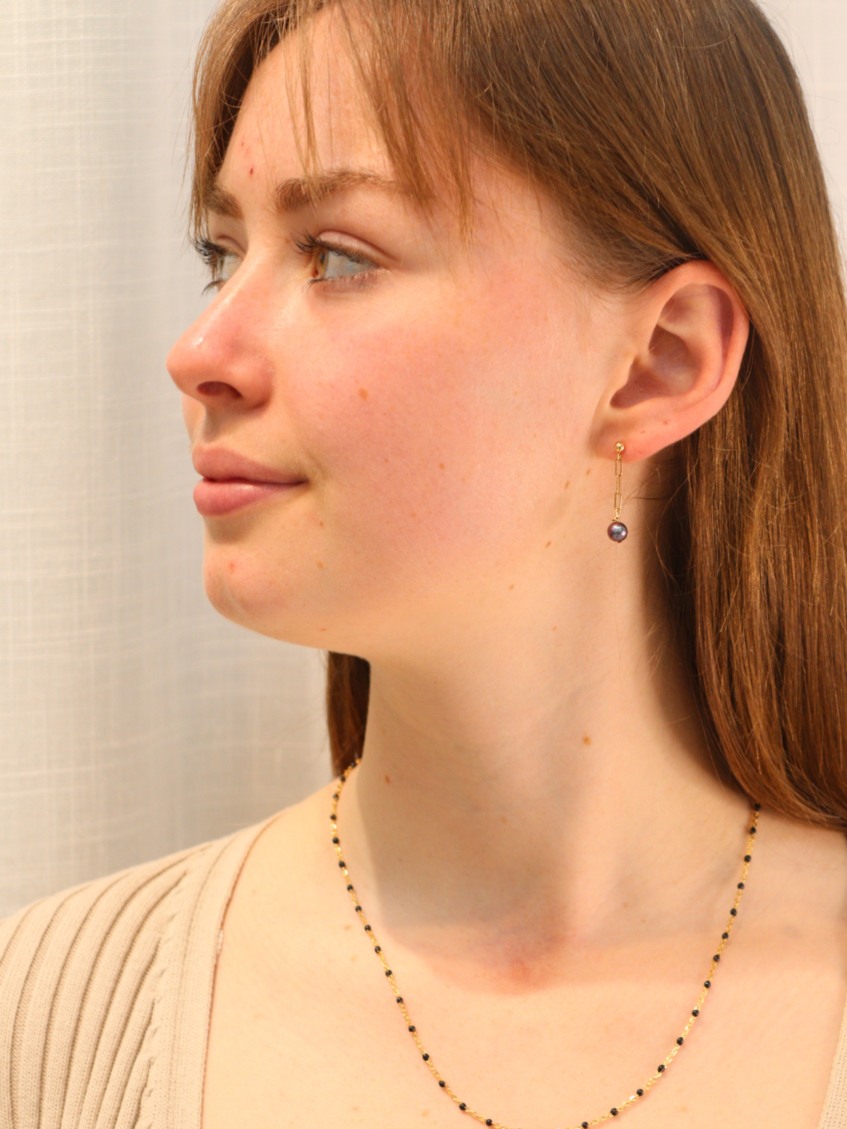 Delicate gold chain link earring featuring a round black pearl pendant.