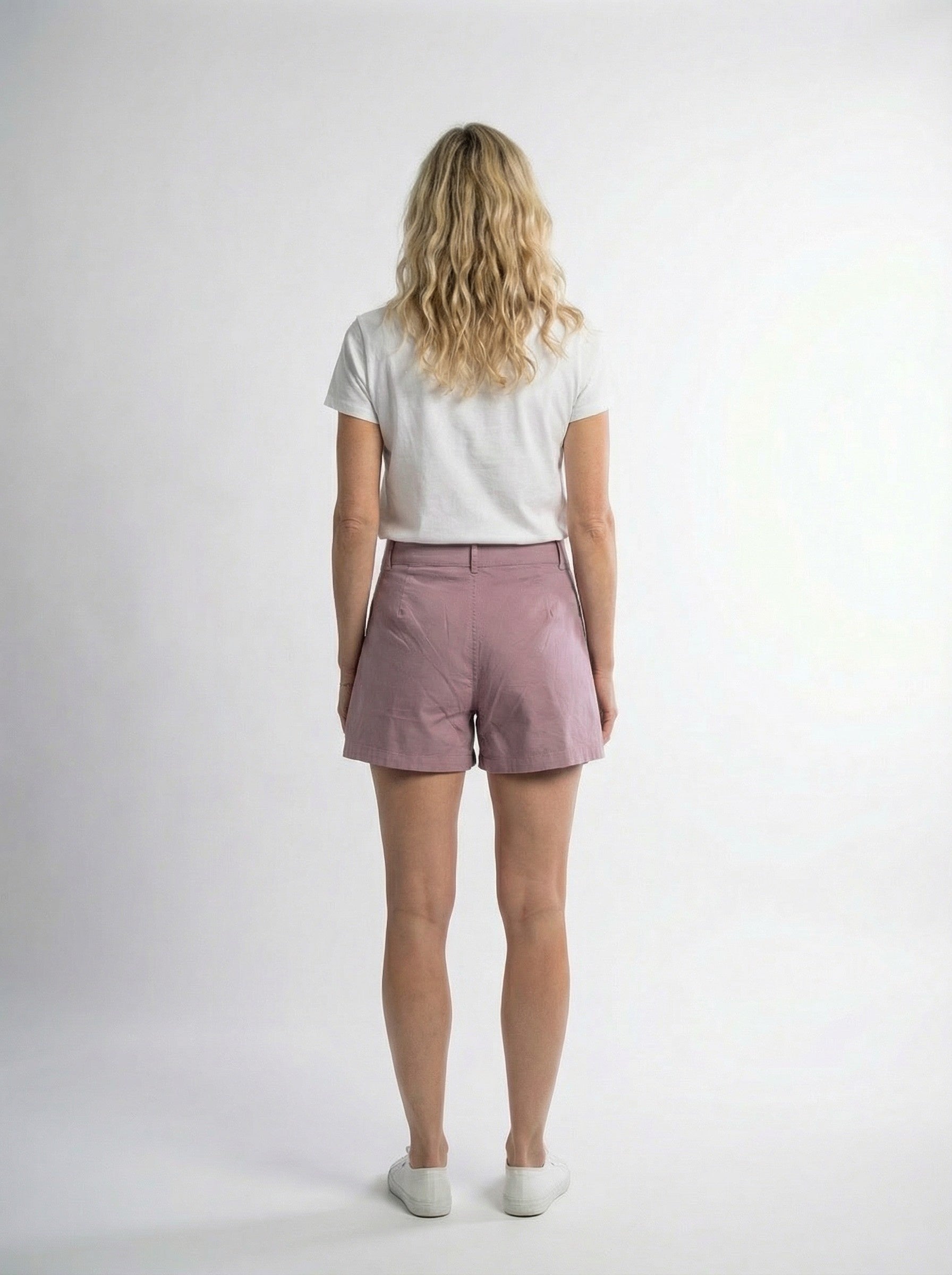 Woman in ethical fashion white t-shirt and mauve shorts, Reca clothing, studio backdrop