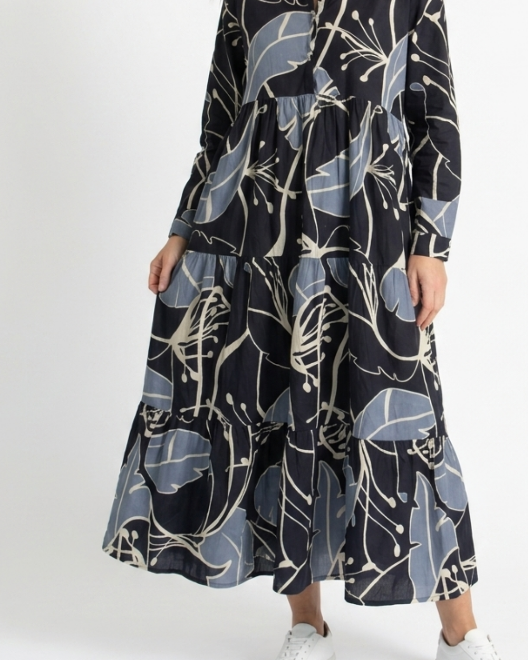 Tiered skirt and hem of the Indigo Bloom cotton midi dress showing the dusty-blue and cream botanical print