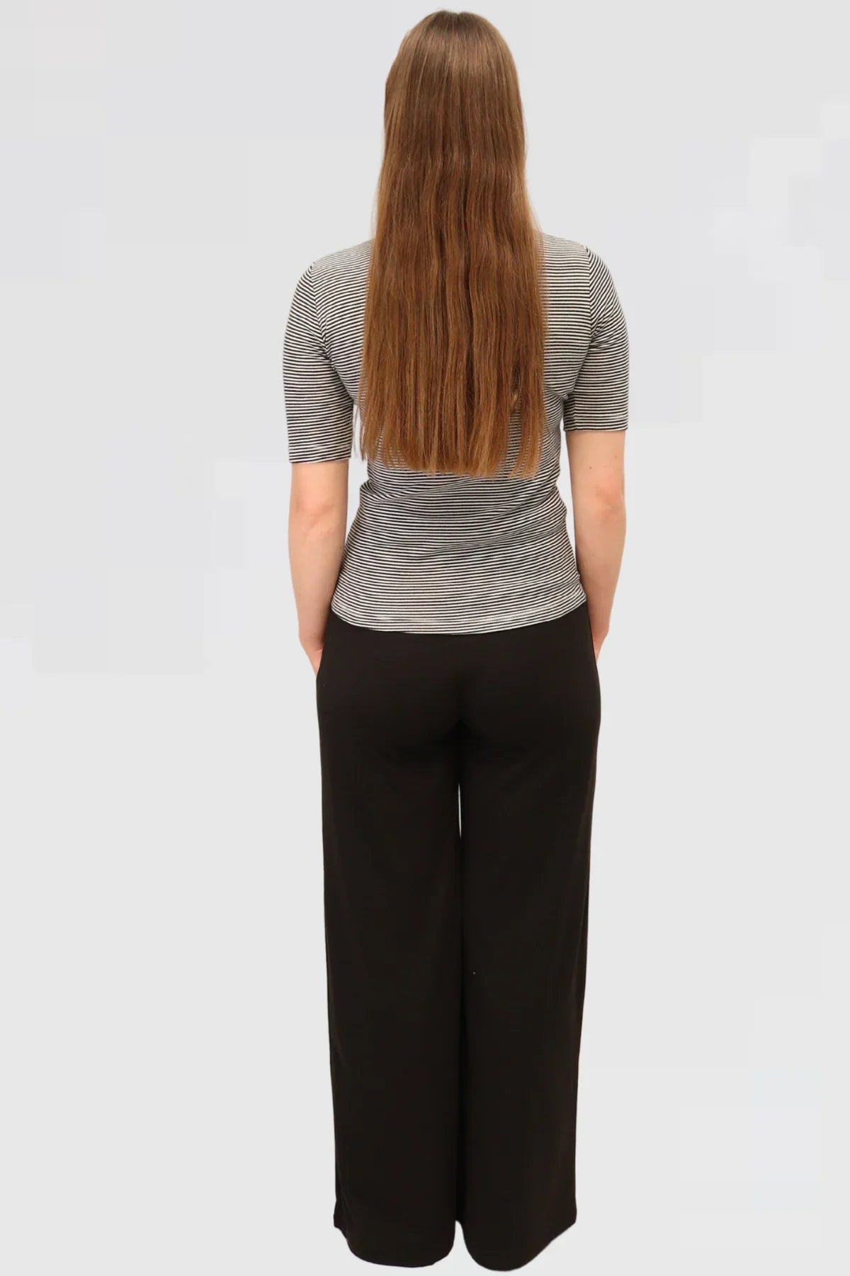 Back view of Reca’s Leisure Lux Pants in black, showing relaxed wide-leg cut and smooth organic cotton-elastane fabric.