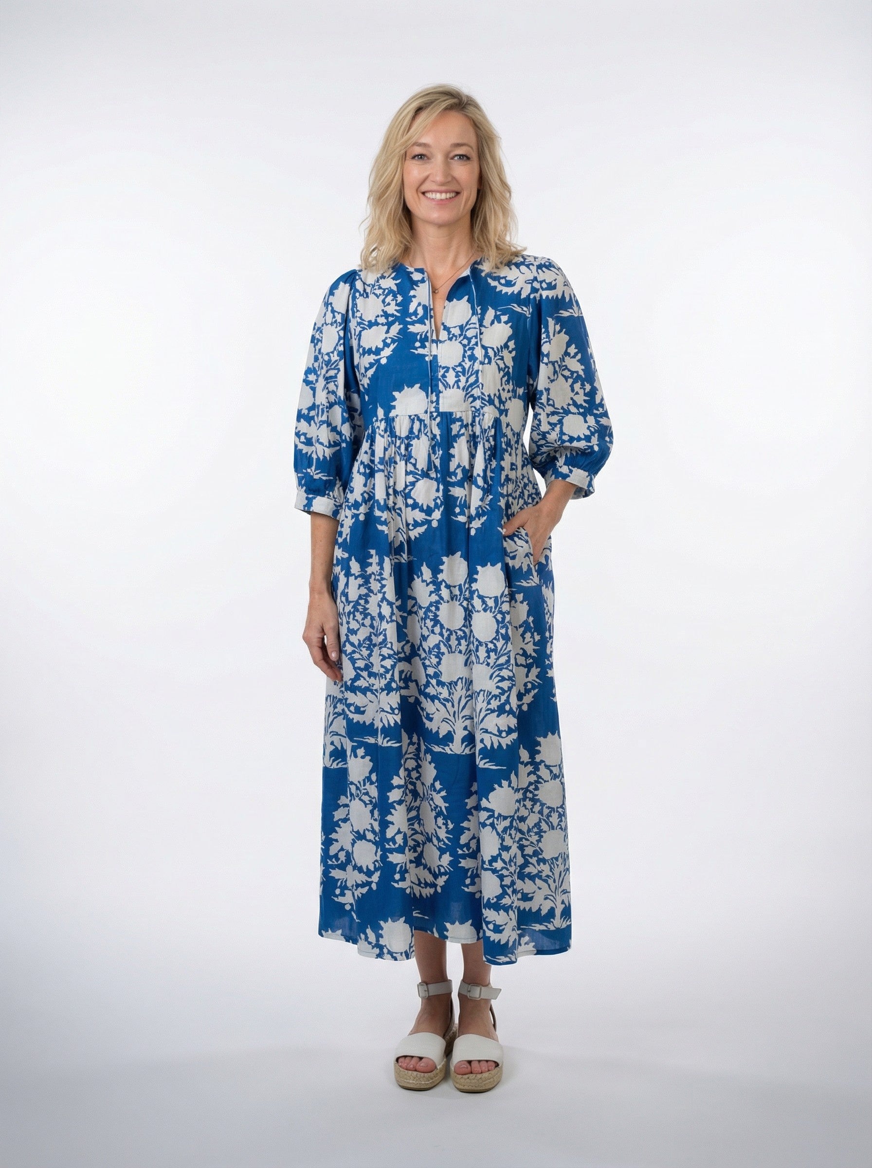 Woman wearing a blue floral dress on a white background