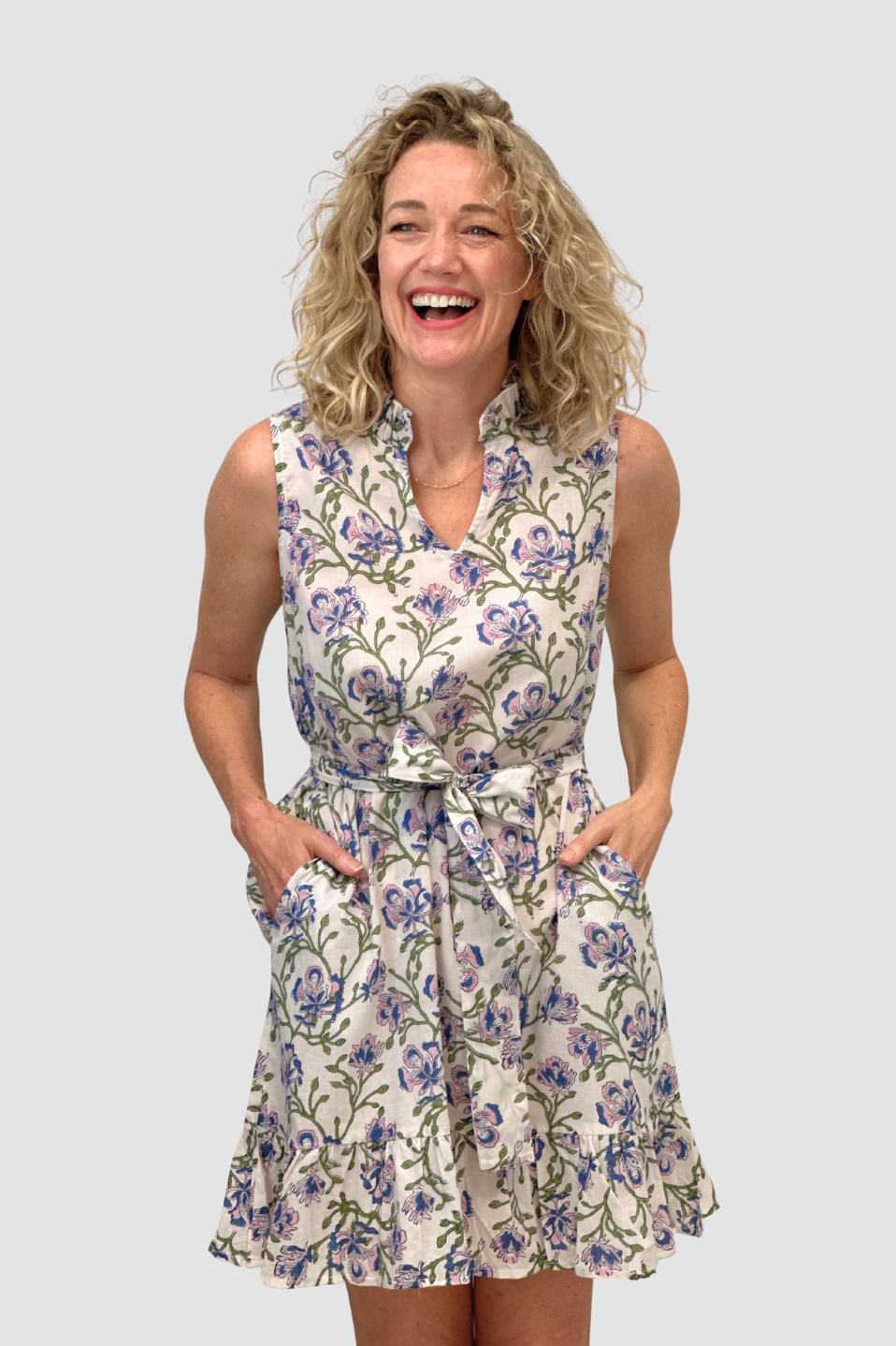 Woman wearing a floral dress/Blue Orchid Garden Dress on a plain background