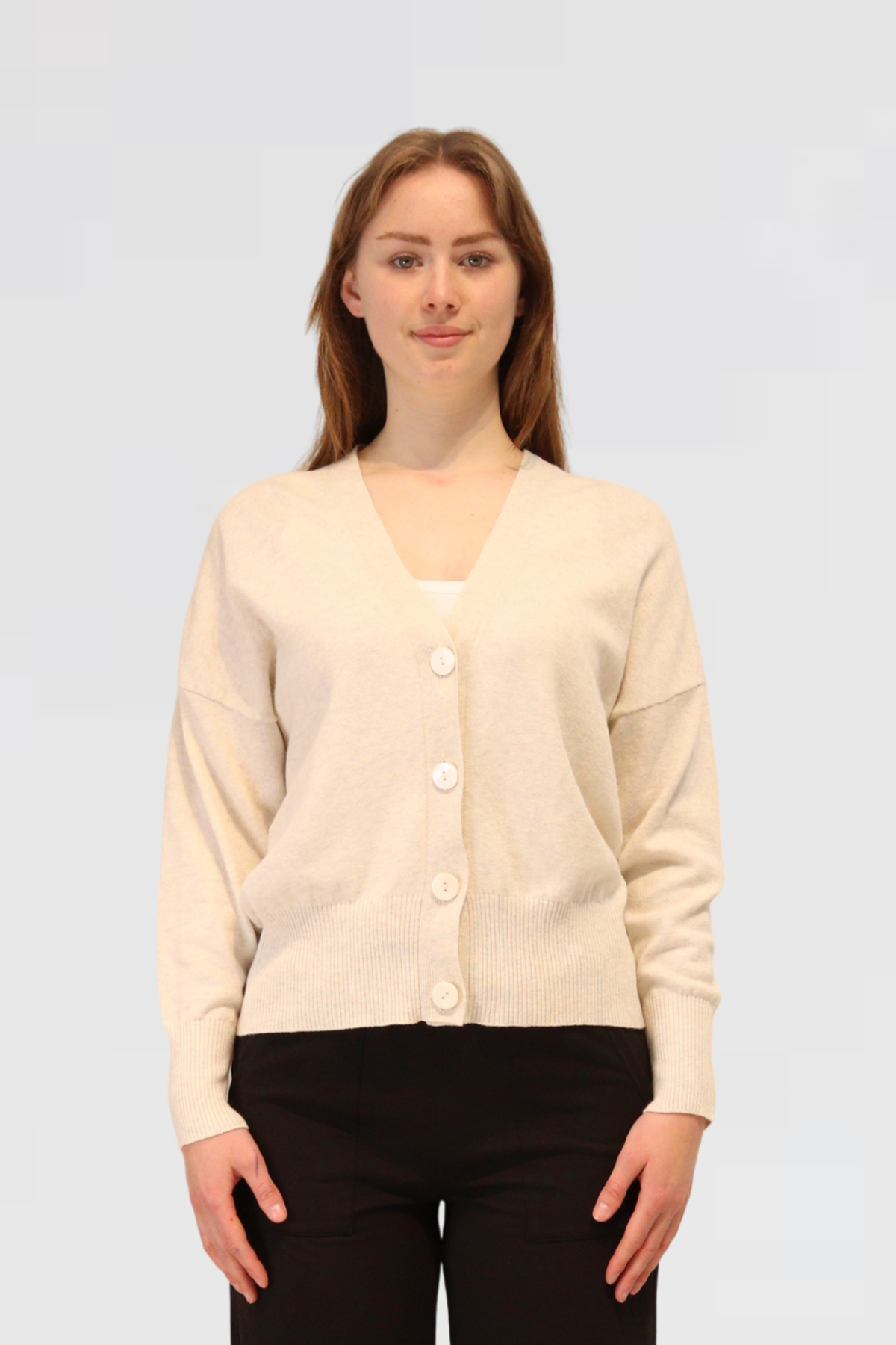 Woman wearing a Cashmere & Cotton Relaxed Cardigan - Grey Marle on a light gray background