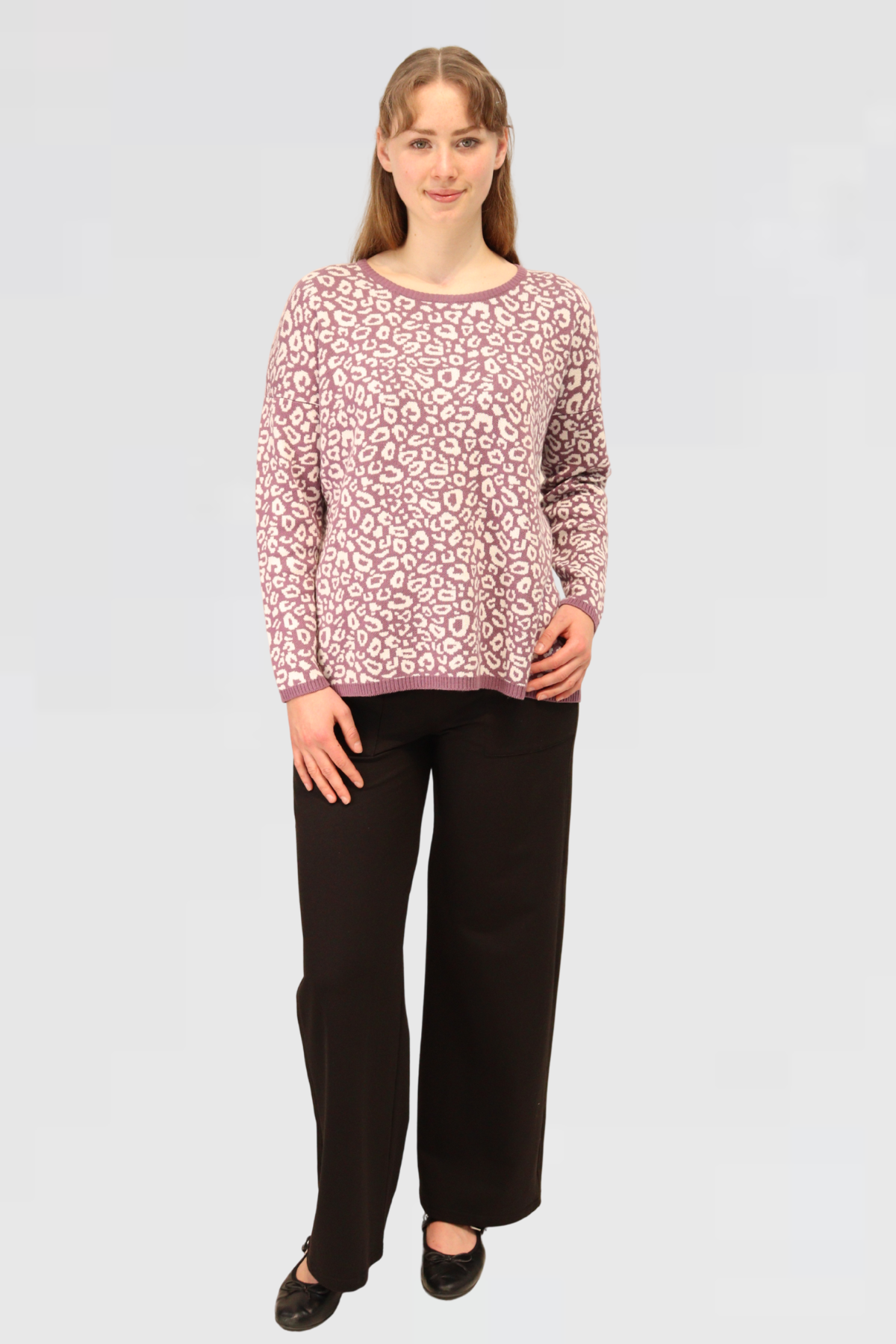 Woman wearing a Cotton Jacquard Sweater - Mauver and black pants on a light gray background
