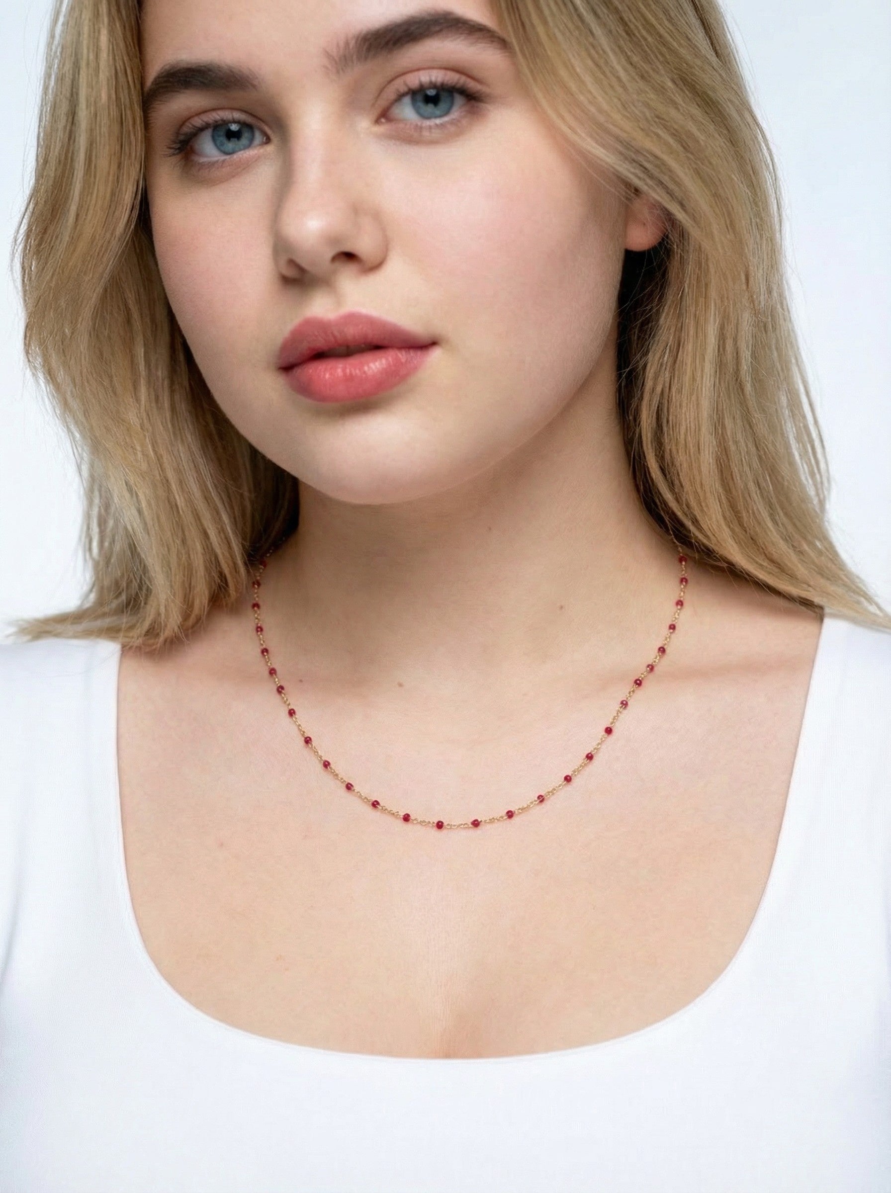 Woman wearing Crimson Enamle Satellite Necklace necklace against a white background