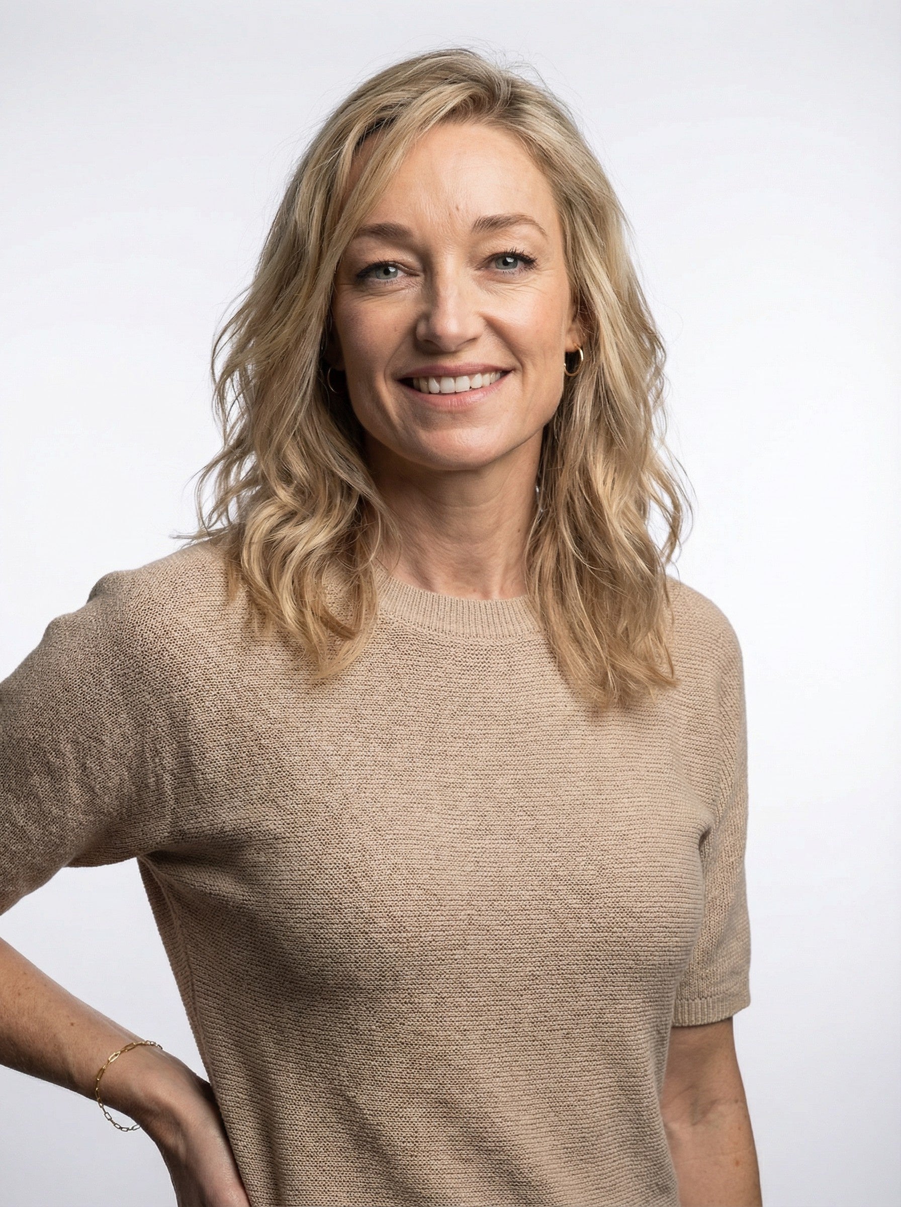 Woman wearing a Gold Paper Clip Bracelet against a plain background