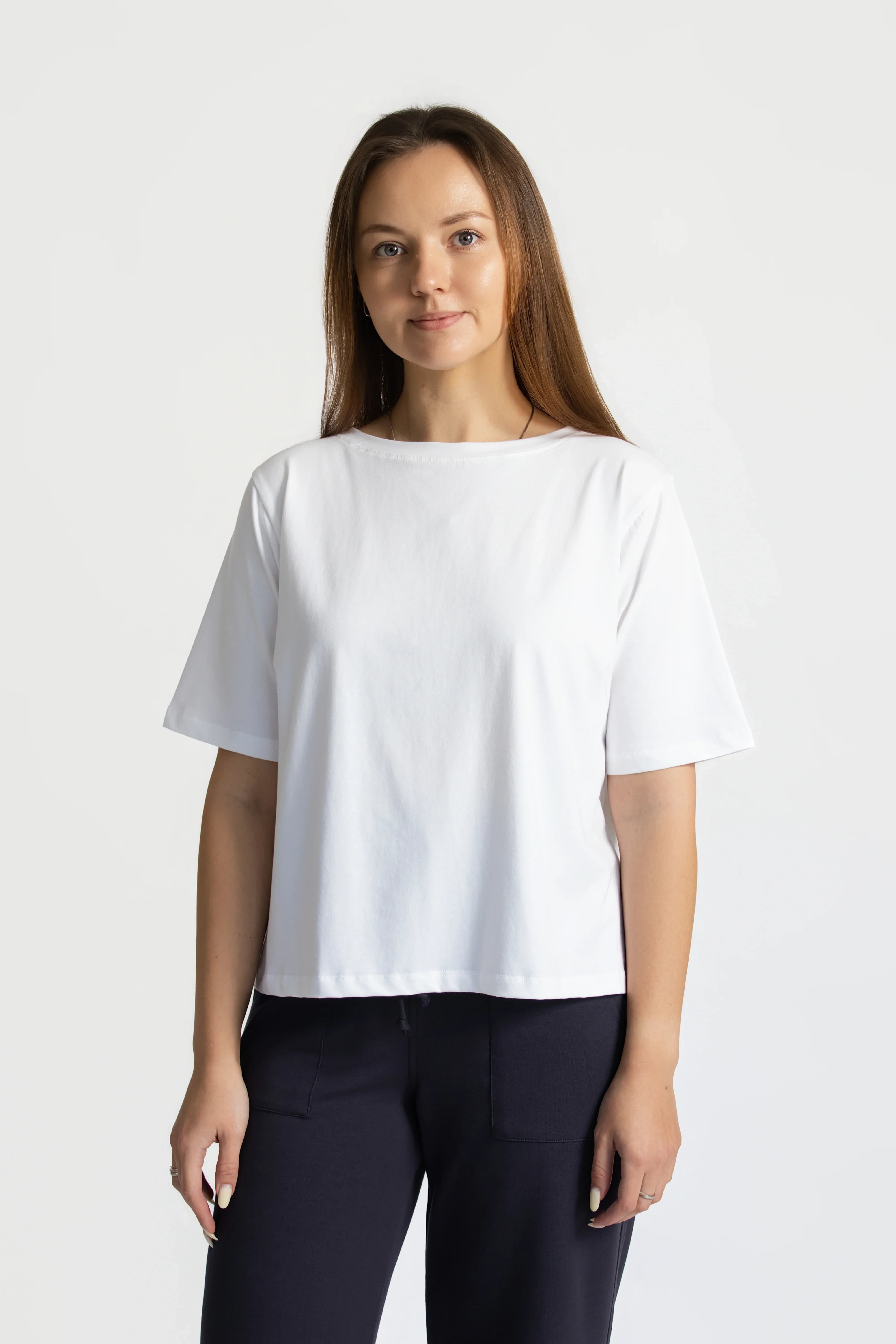 Model wearing the organic flex crew tee in white and organic wide-leg pants in slate on a plain background